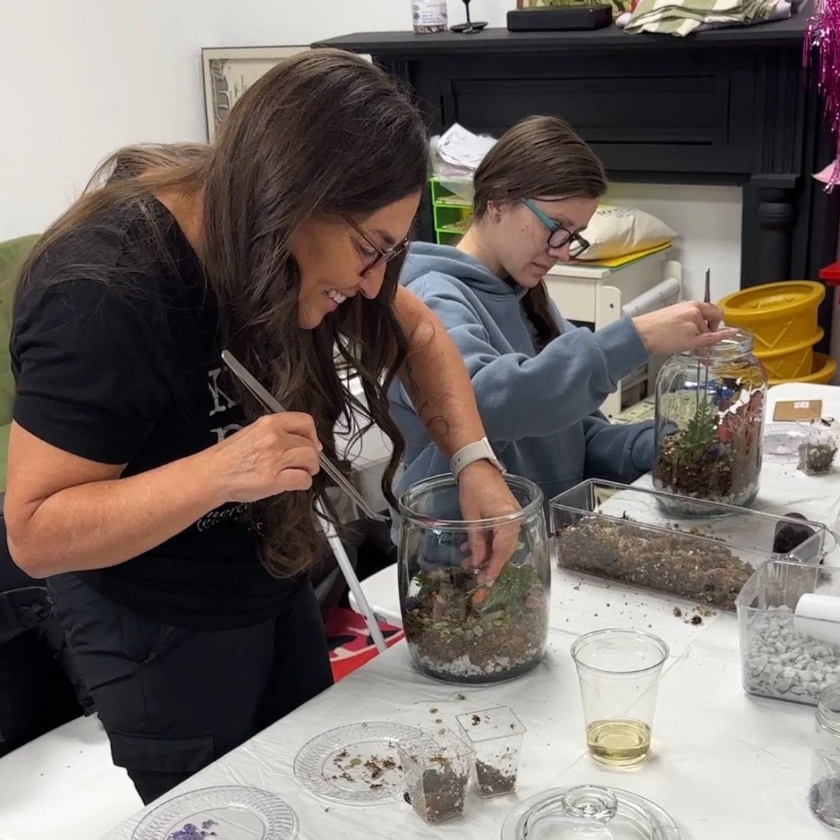 Lauren White guides participants through a terrarium-building workshop, creating a fun and engaging community experience through plants.