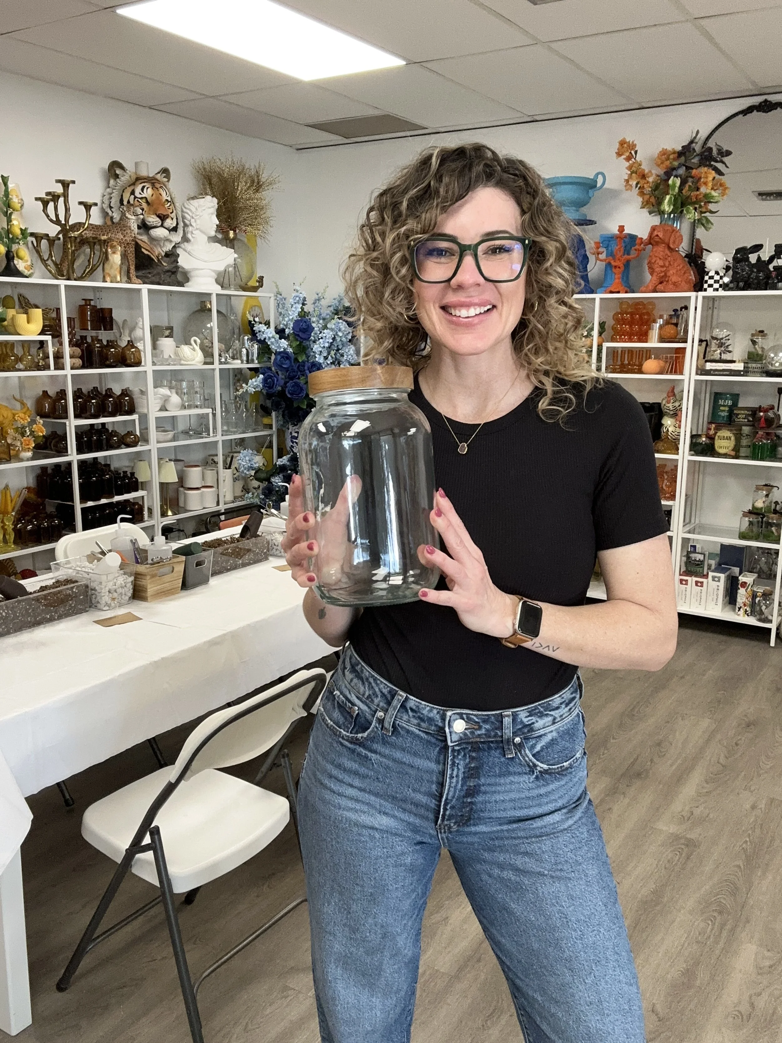 Lauren of Lauren and Plants holding a glass vessel for a private terrarium workshop in DFW.