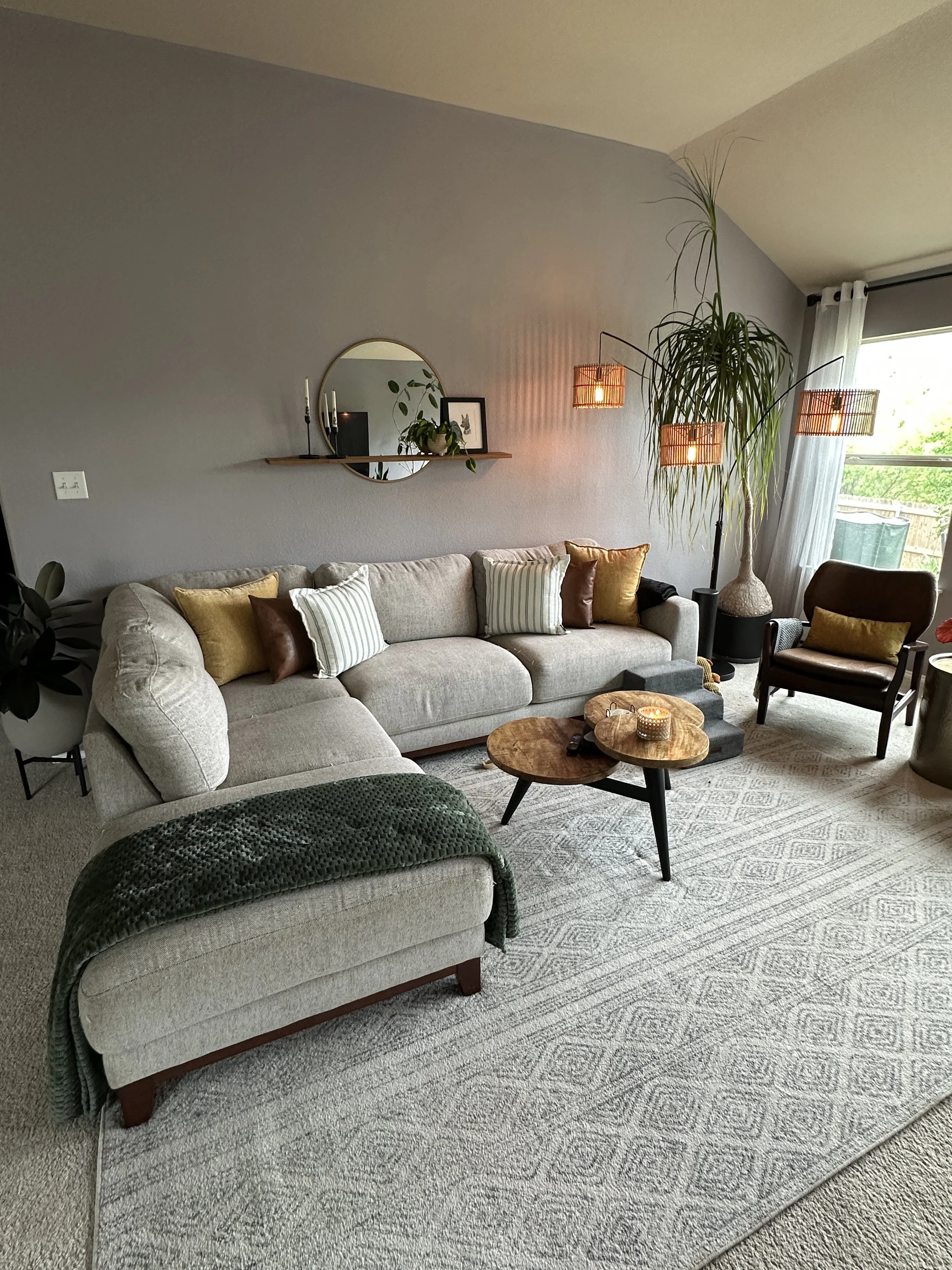 Calming living room featuring indoor plants, warm lighting, organic textures, and intentional biophilic interior design that creates a peaceful and grounded atmosphere.