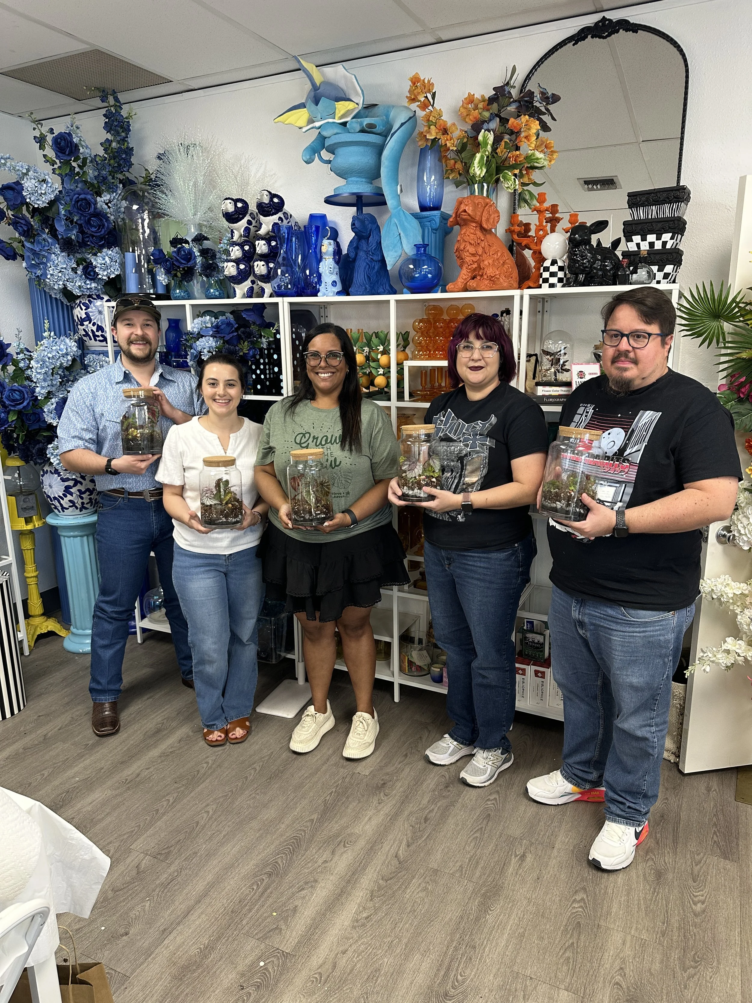 Group holding completed terrariums at a Lauren and Plants workshop in the Dallas Fort Worth area
