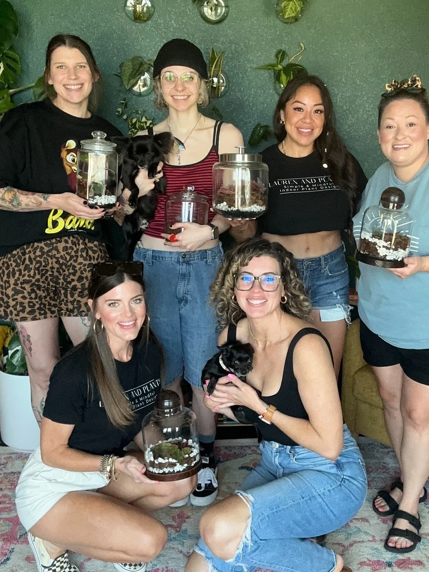 Private in-home terrarium workshop with Lauren and Plants in Fort Worth featuring participants holding terrariums and small dogs.