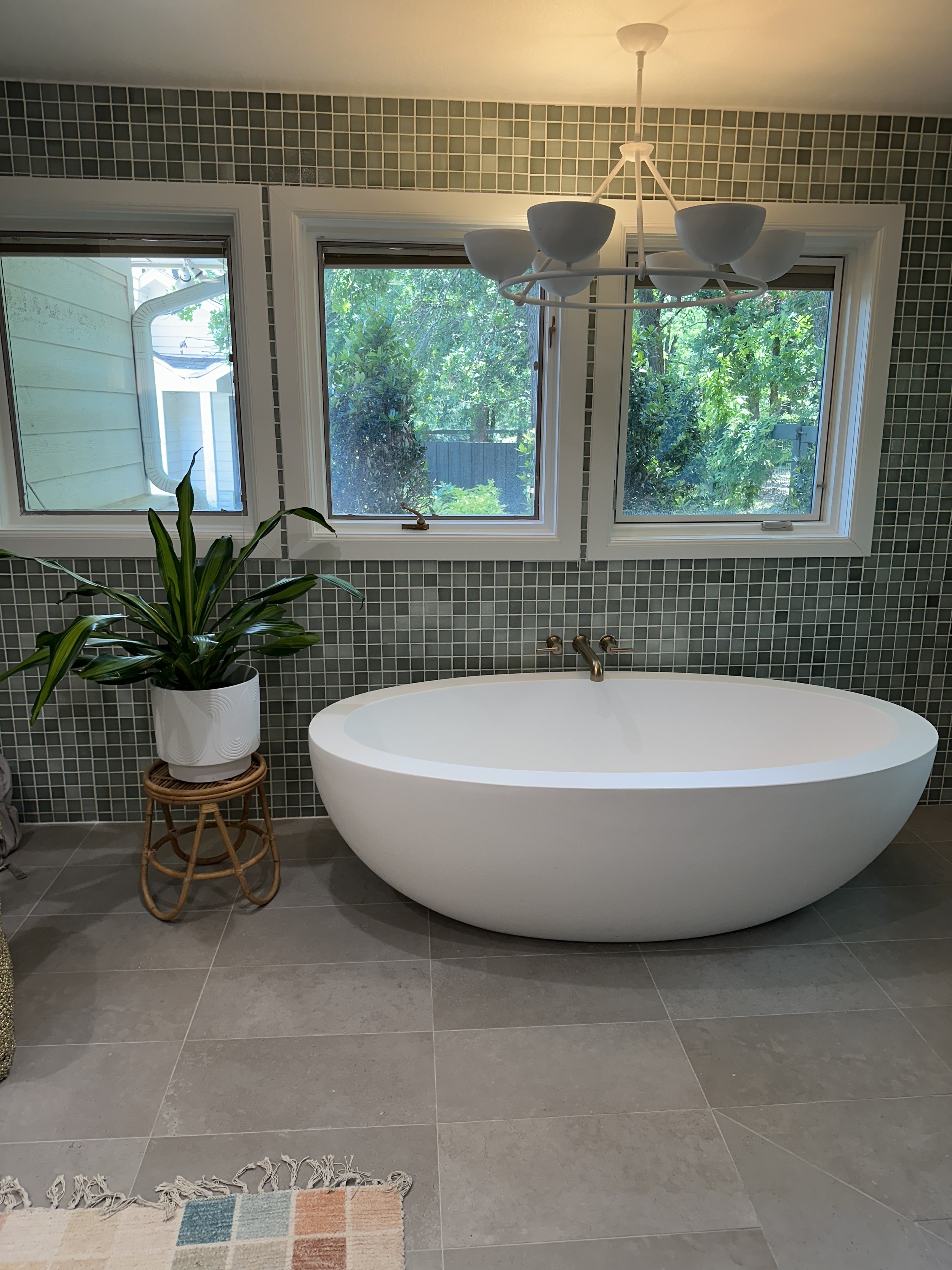 Minimal bathroom plant styling with a statement plant beside a freestanding tub creating a spa-like atmosphere