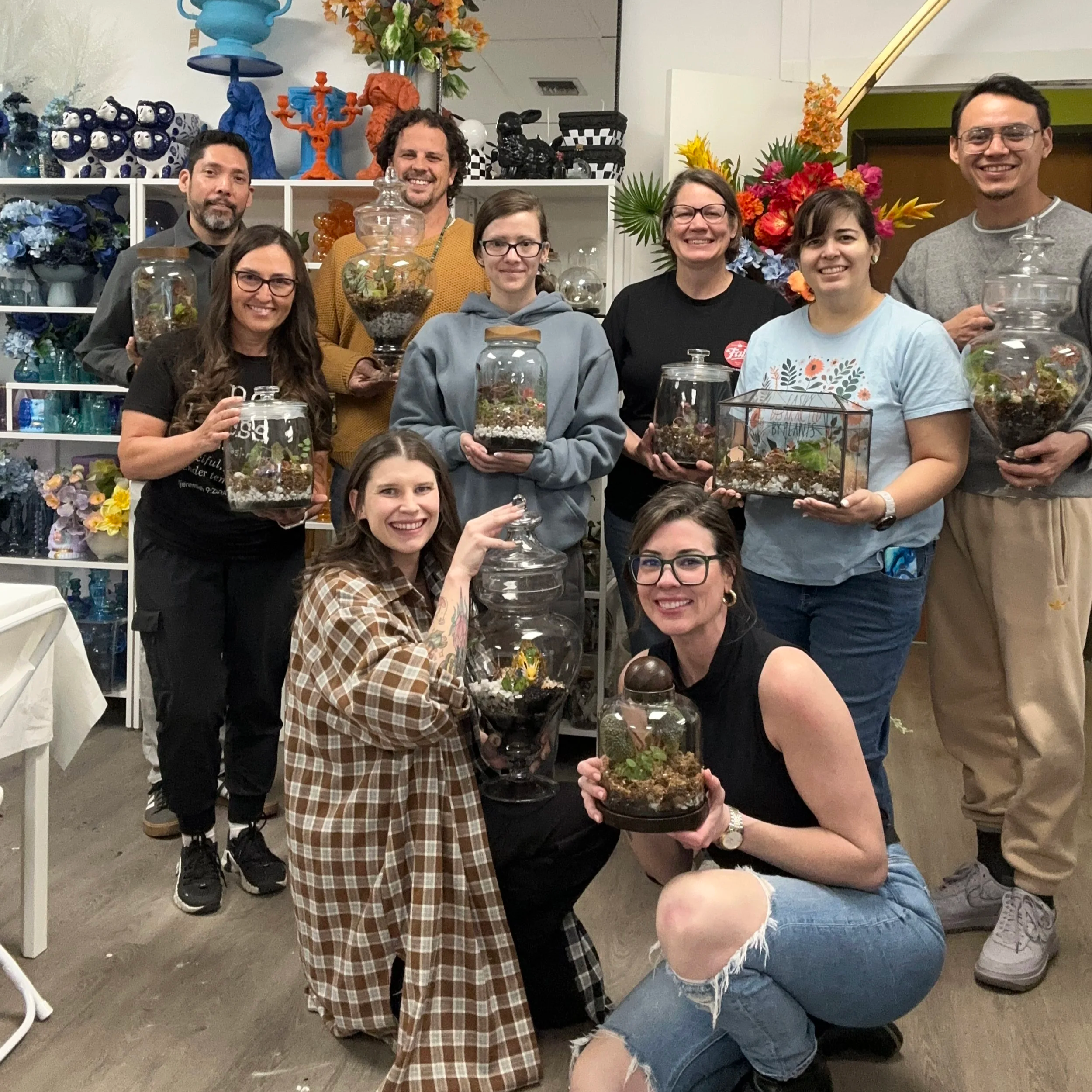 Group photo of participants holding finished begonia terrariums after a Lauren and Plants terrarium workshop in the Dallas–Fort Worth area.