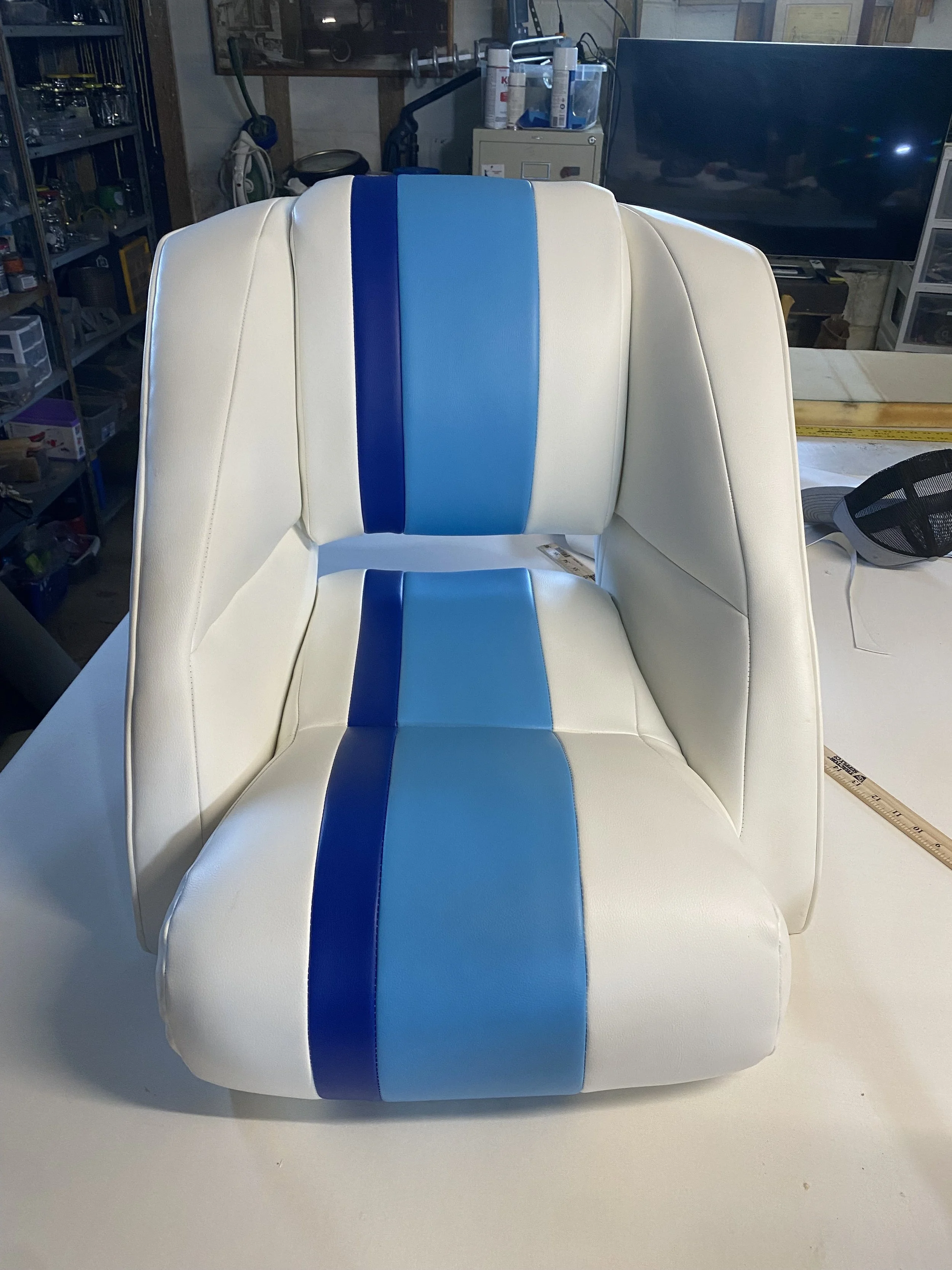 Reupholstererd boat seat in white and blue marine-grade vinyl by Inlow Upholstery in Lawndale, NC