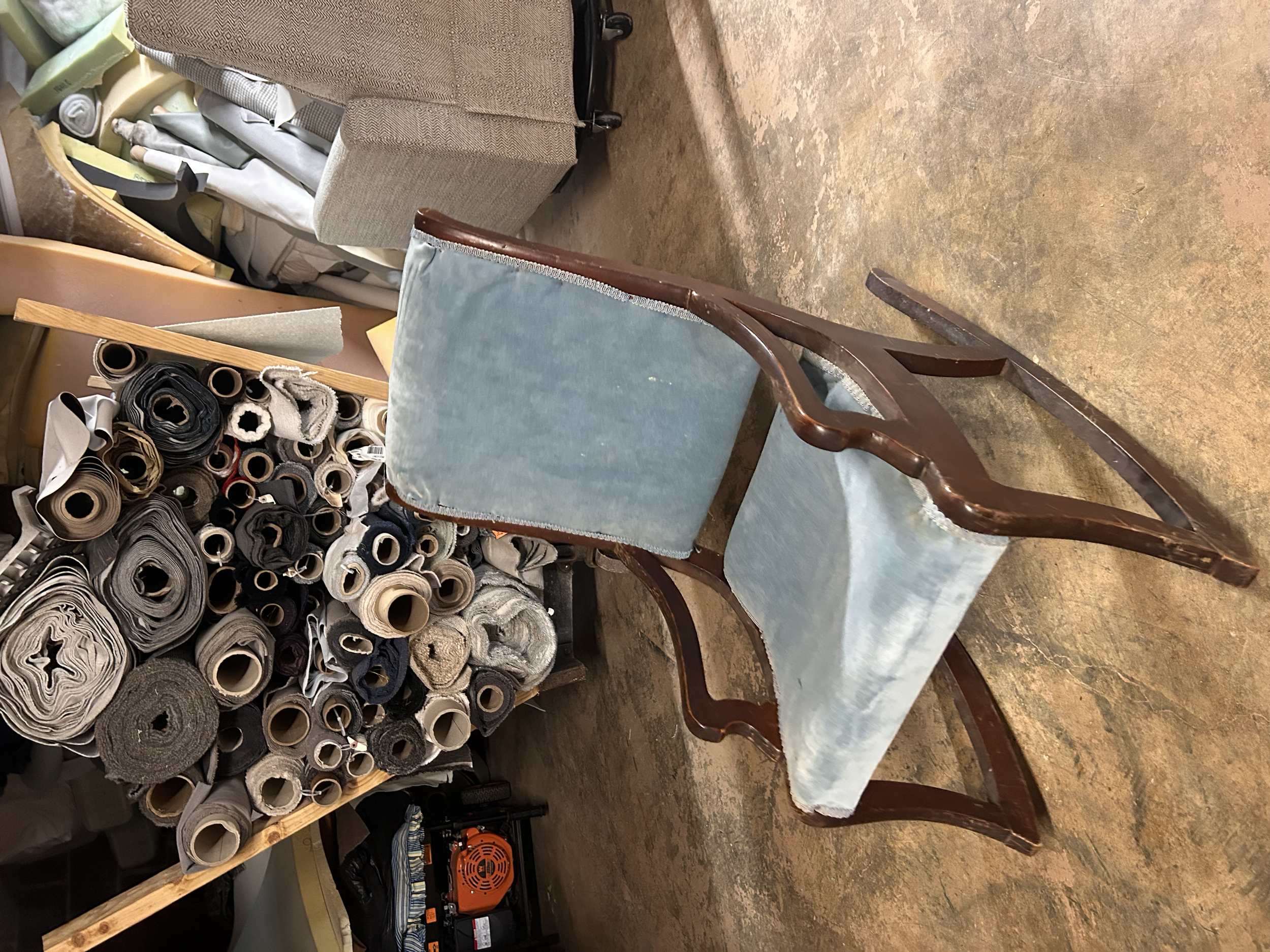 Before upholstery: Vintage wooden rocking chair with faded blue upholstery and a dark wood frame, ready for a fresh fabric update.