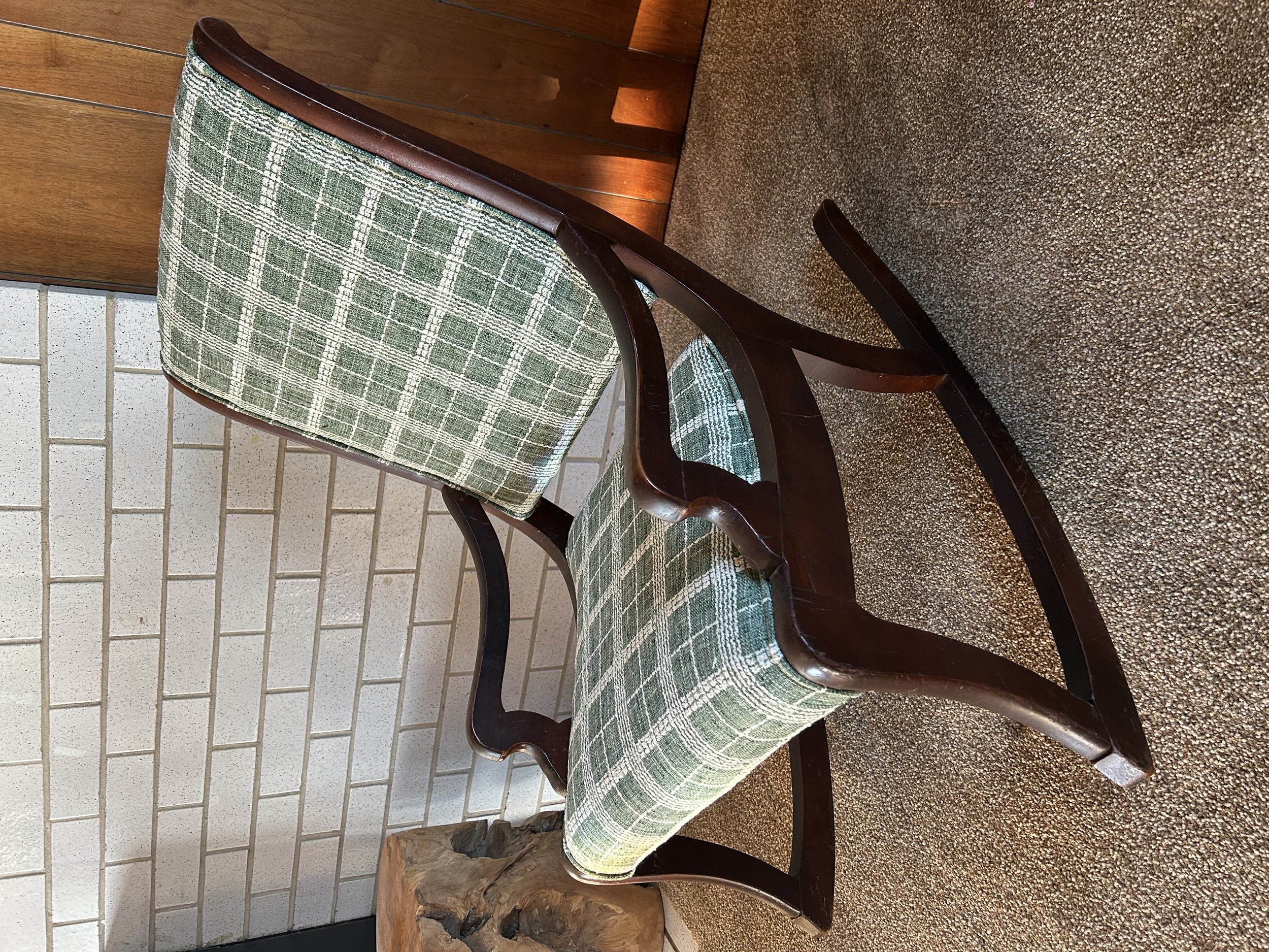 Vintage wooden rocking chair reupholstered in textured green and cream plaid, complementing its dark wood frame and curved arms.