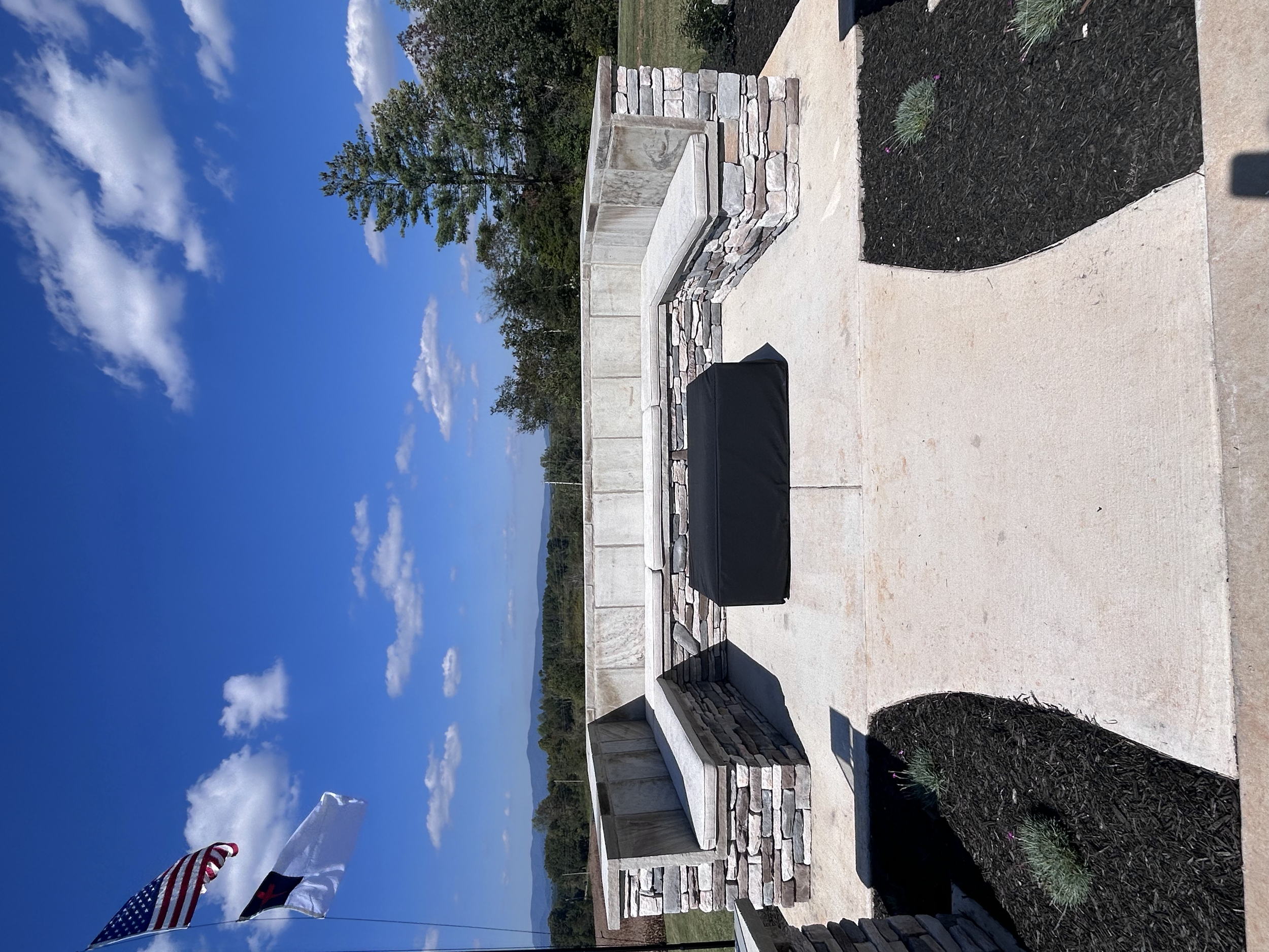 Custom outdoor cushions tailored to fit this built-in stone bench, adding comfort and a finished look to the firepit seating area. 