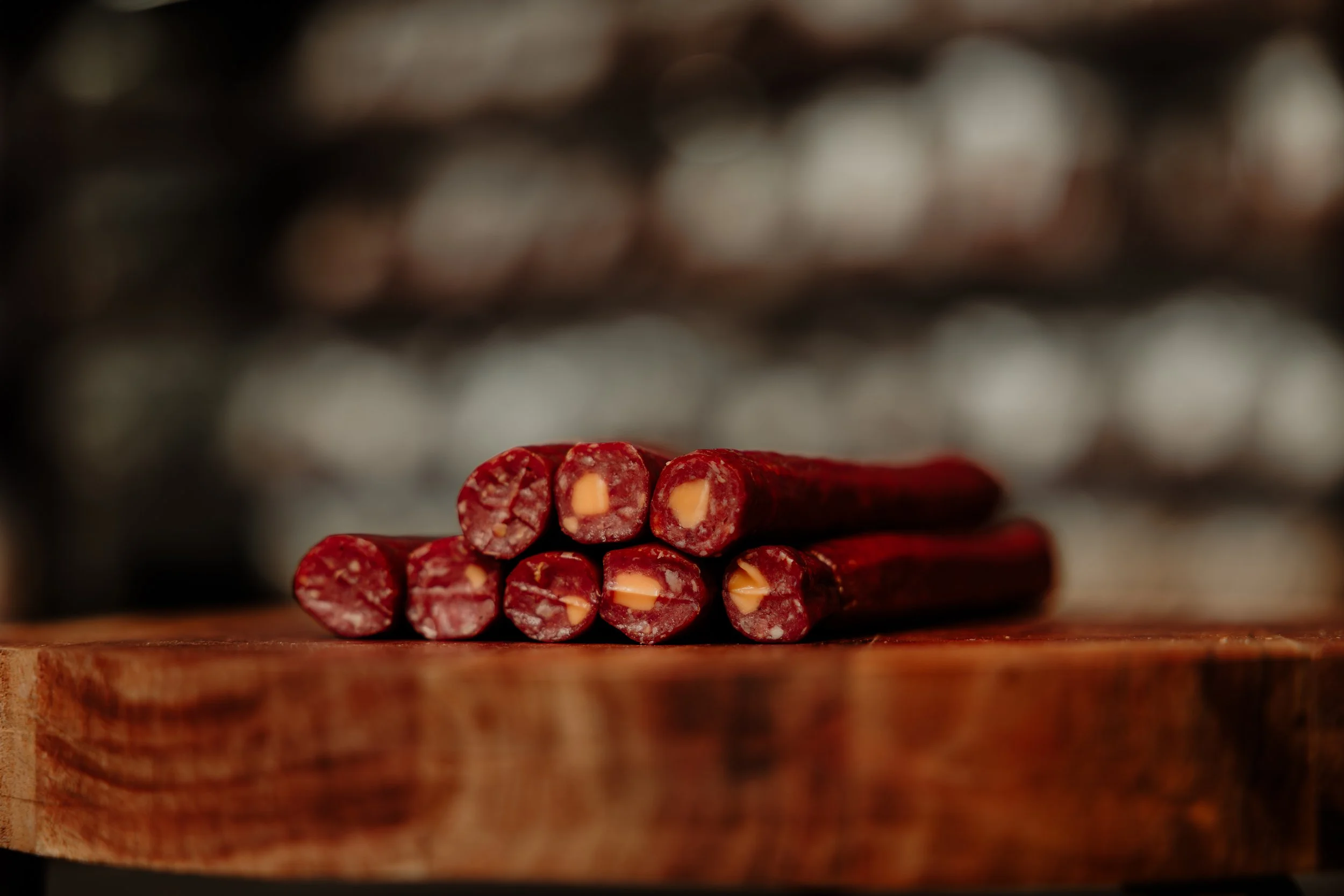 A close-up of red licorice sticks with white centers on a wooden surface, with a blurred background.