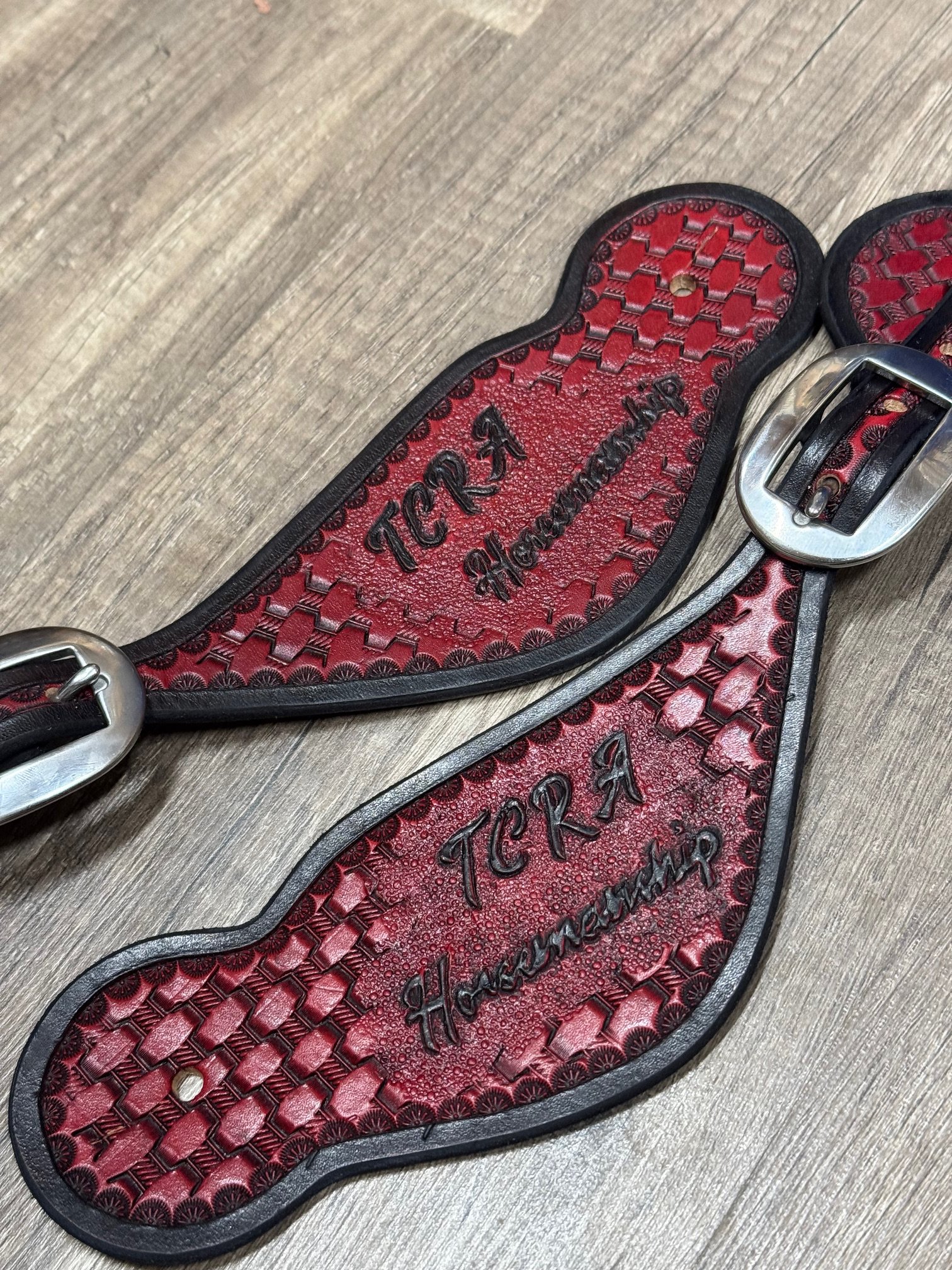 A pair of spur straps with a red and black textured insole, labeled with the brand name 'TGR8 Horsewear'.