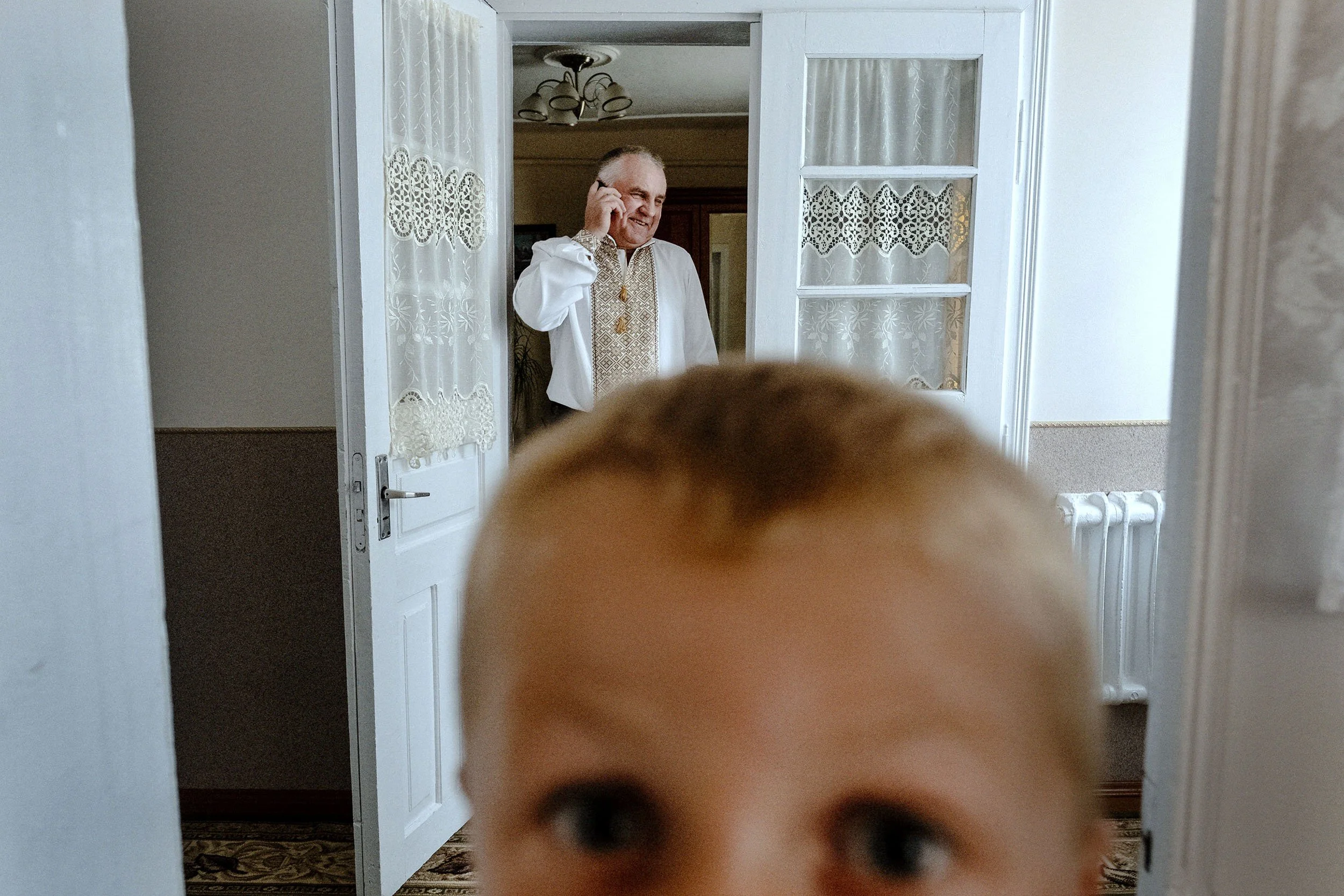 Stasic and his grandfather  in their traditional clothing ready to go to church for a christening.