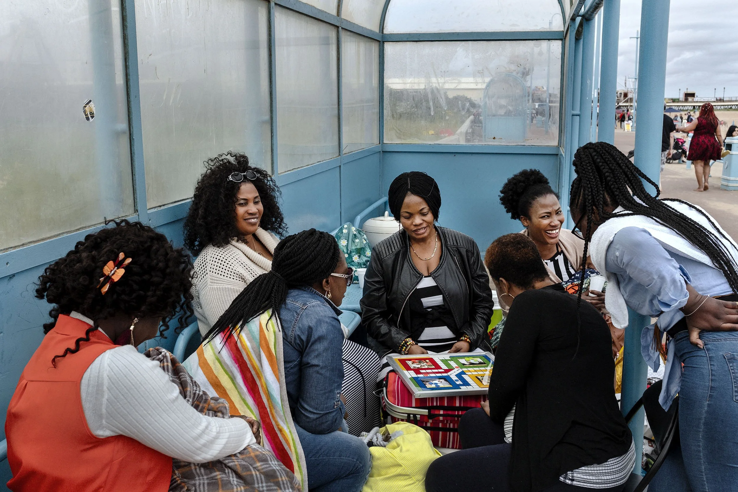 A group of ladies playing a board game in a shelter on the boulevard of Skegness, England.