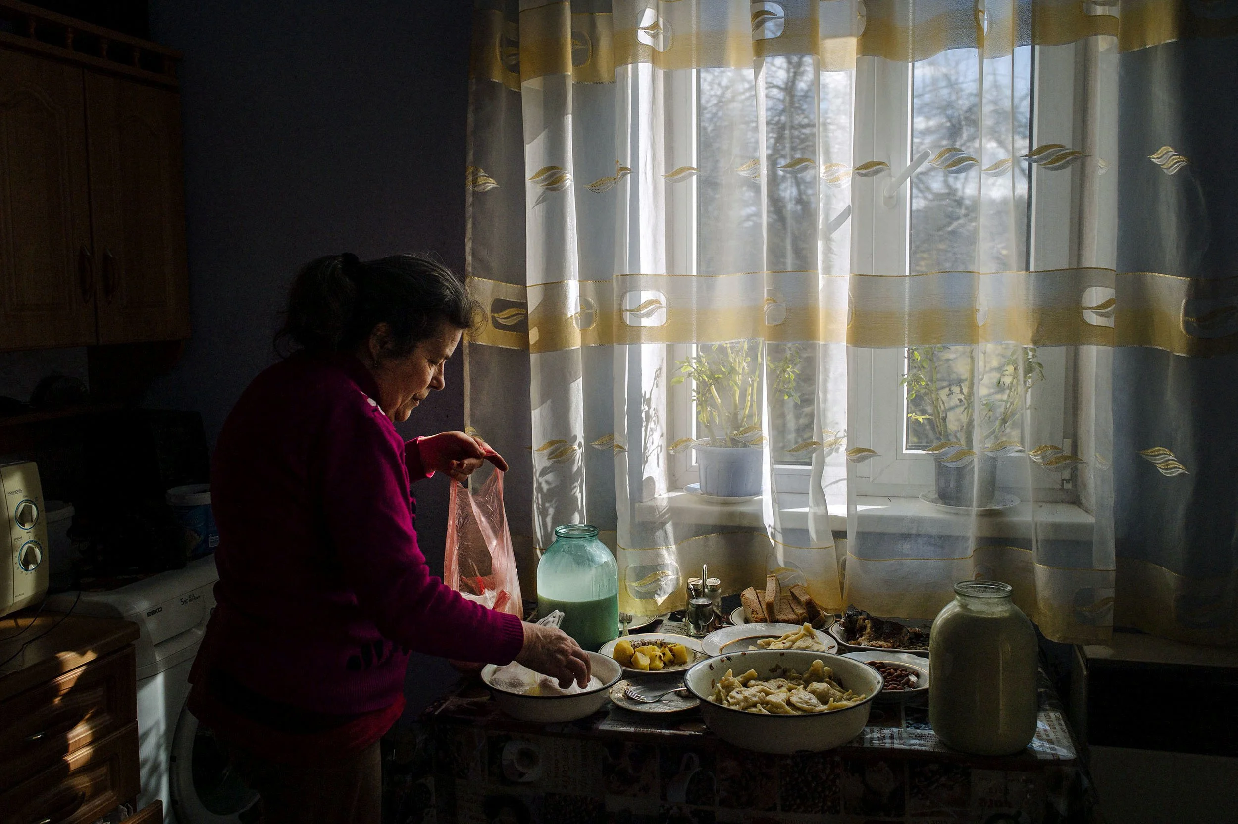 A grandmother cooks for her grandchildren.