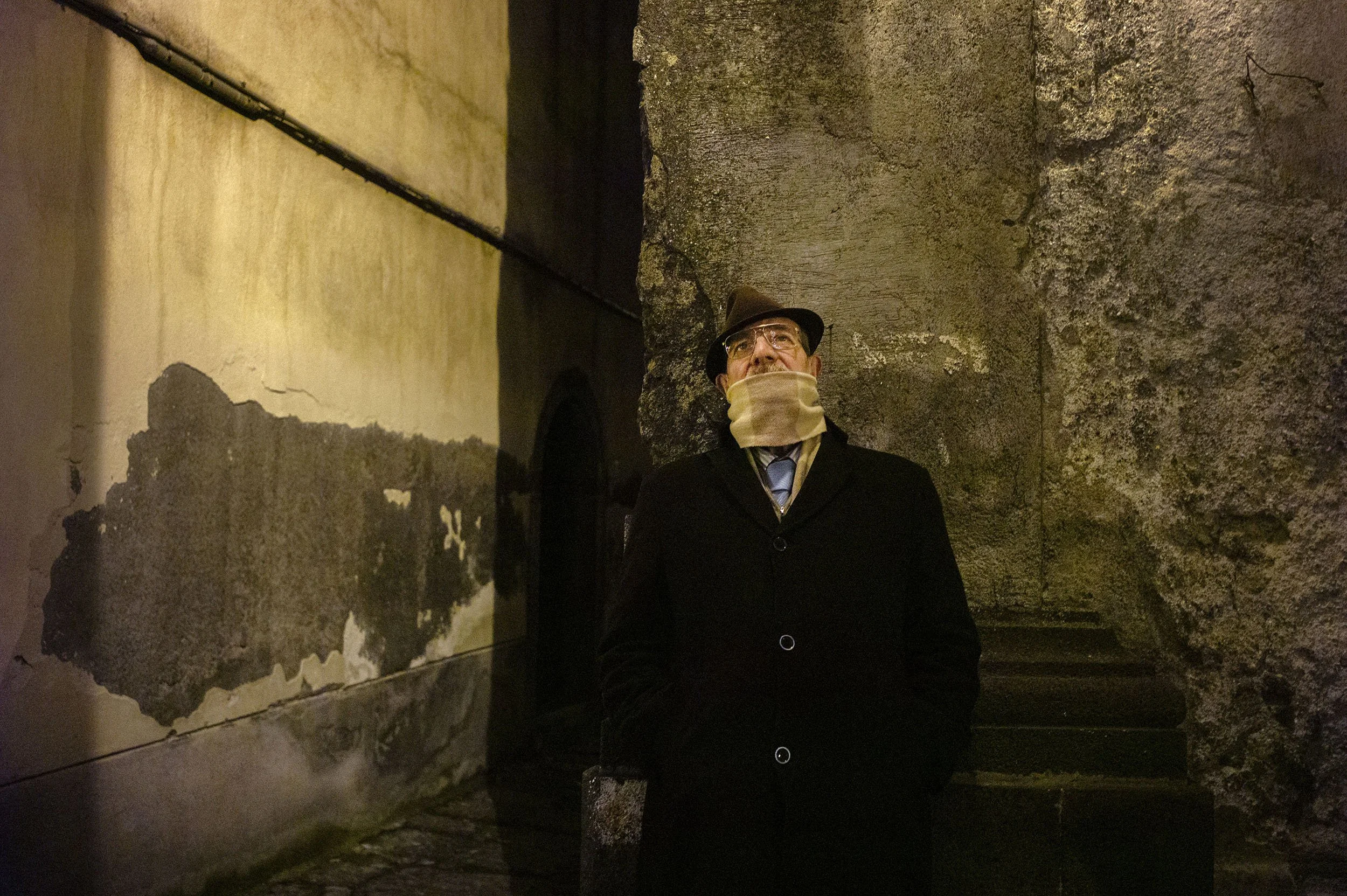 A man looks at the statue of Jesus carried on the shoulders of the men of the church. Randazzo, Sicily.