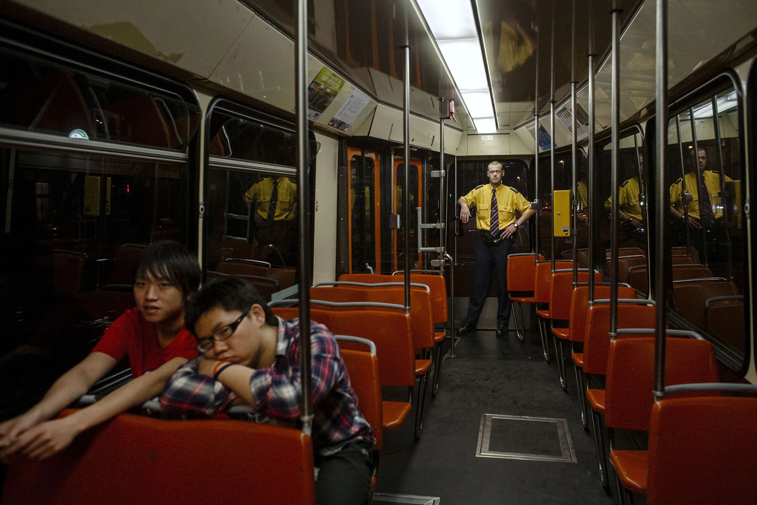 A tram conductor rides with two passengers late at night in Rotterdam, the Netherlands.