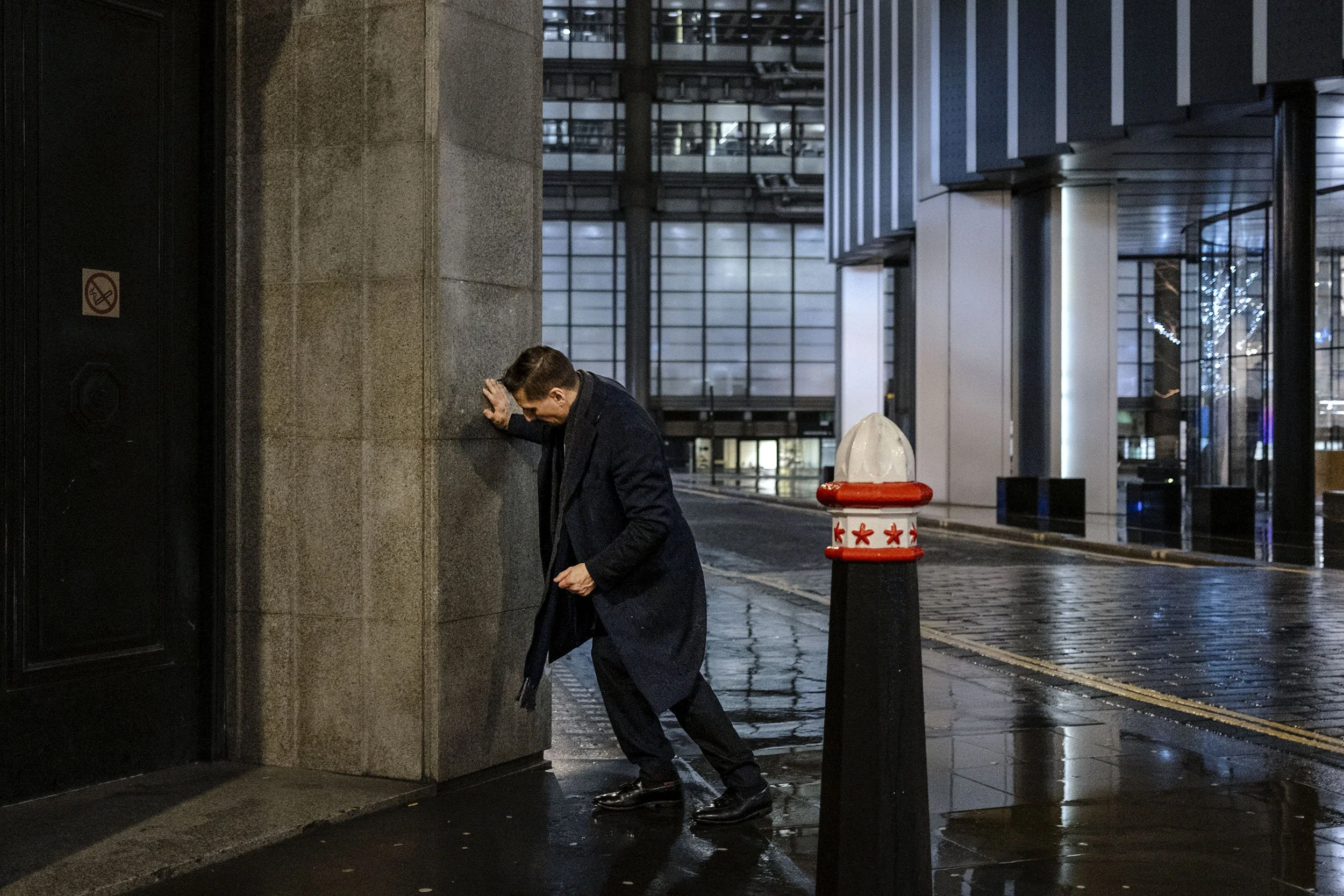 After work, a suited man stumbles around drunk in the City in London, England.