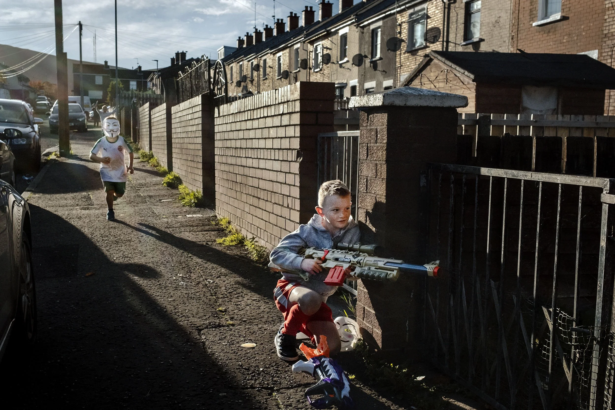 Kids play war on the catholic side of the Ardoyne estate. Belfast, Northern Ireland.