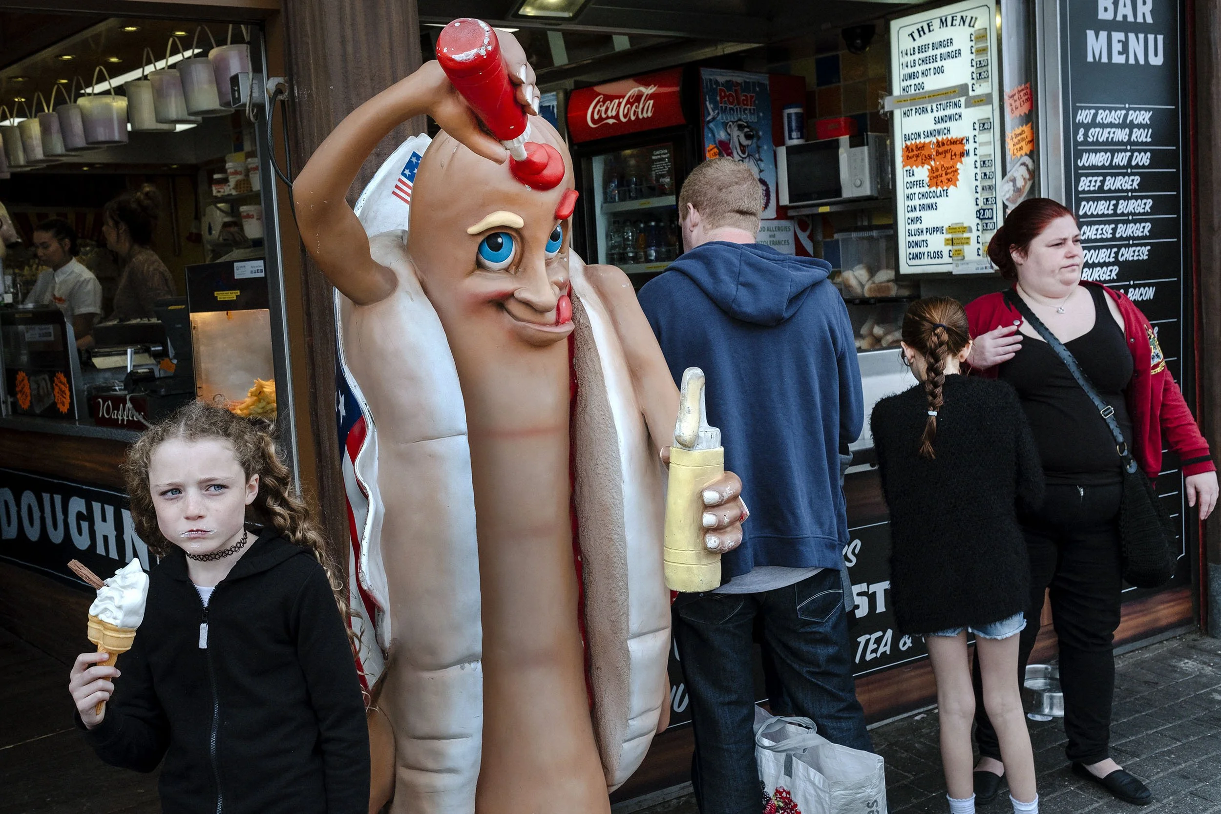 A young girl eats an ice-cream outside an eatery in Bridlington, England.