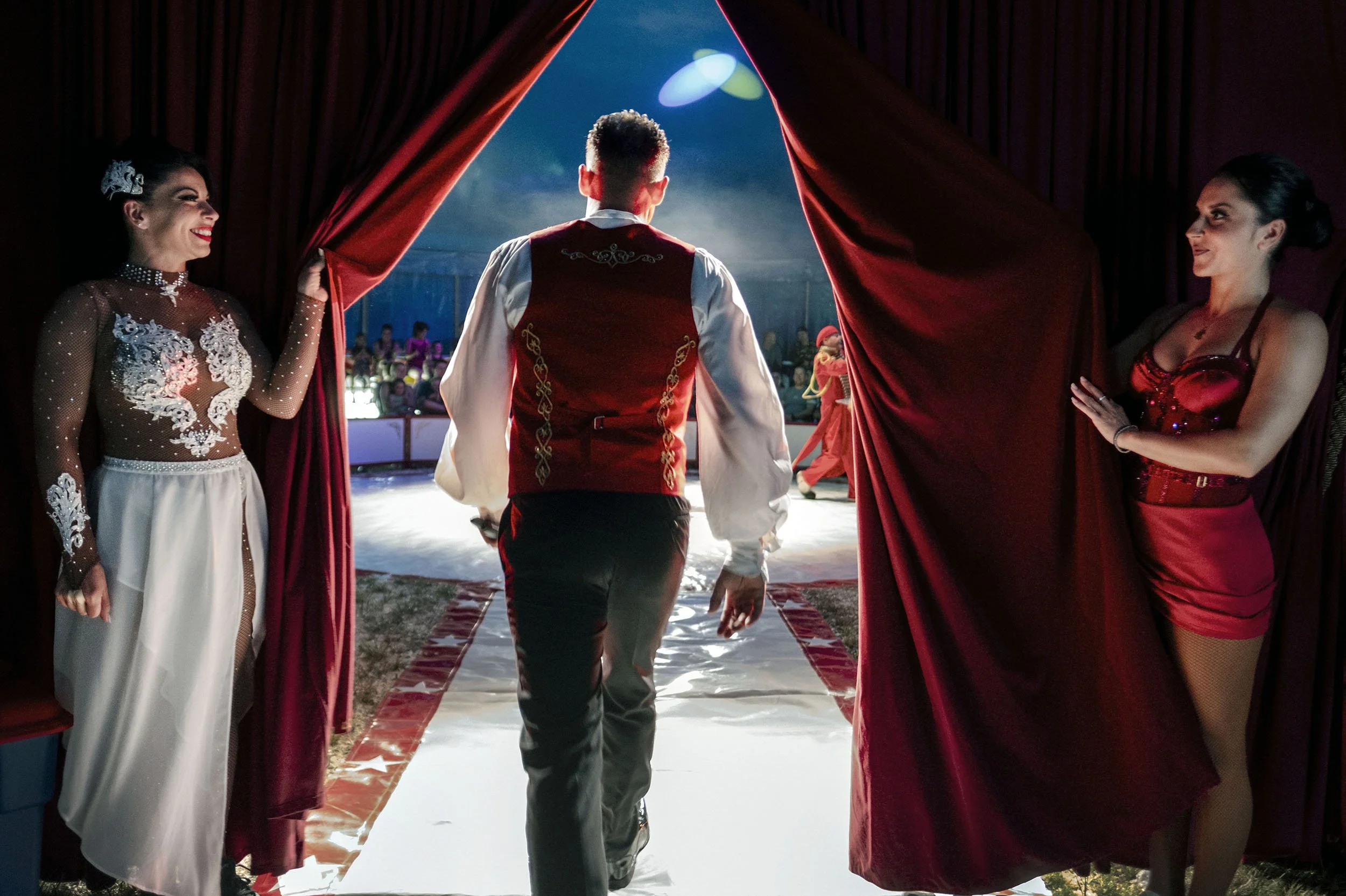 Kevin walks into the arena of his Circus Harlekino, as Emi Velkova and Maria Kellner hold open the curtain in Bladel, the Netherlands.