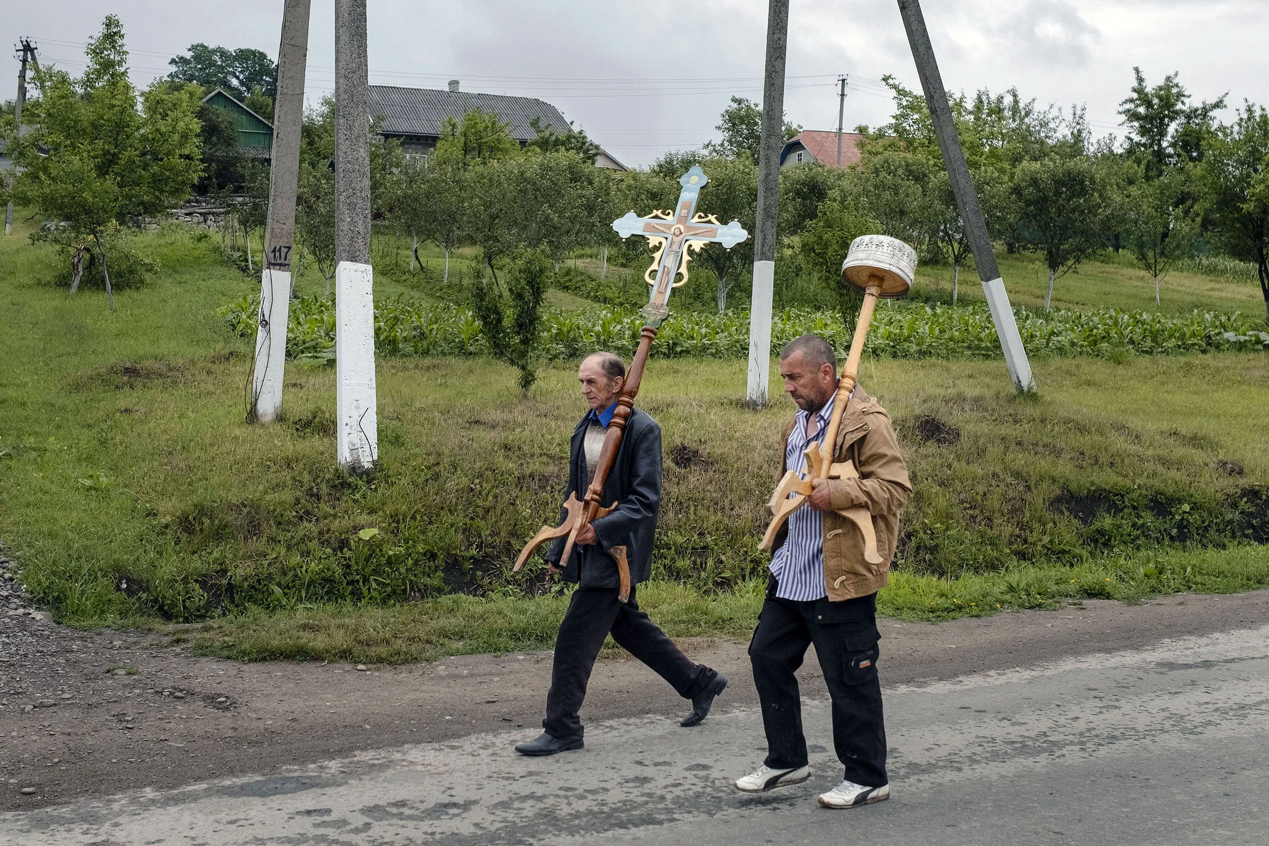 Two men walk with ornaments toward their church.