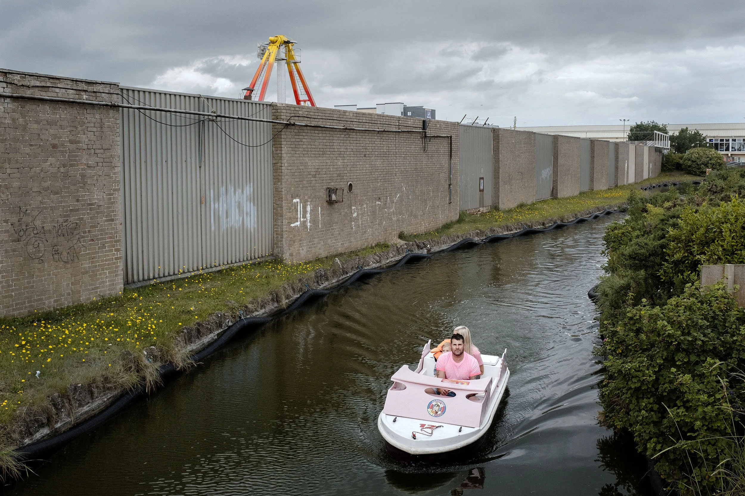 A couple in a pleasure boat ride along the exterior of Pleasure Beach. Skegness, England. I found it remarkable that someone would pay money to sit in a boat that goes along a ride with no view.