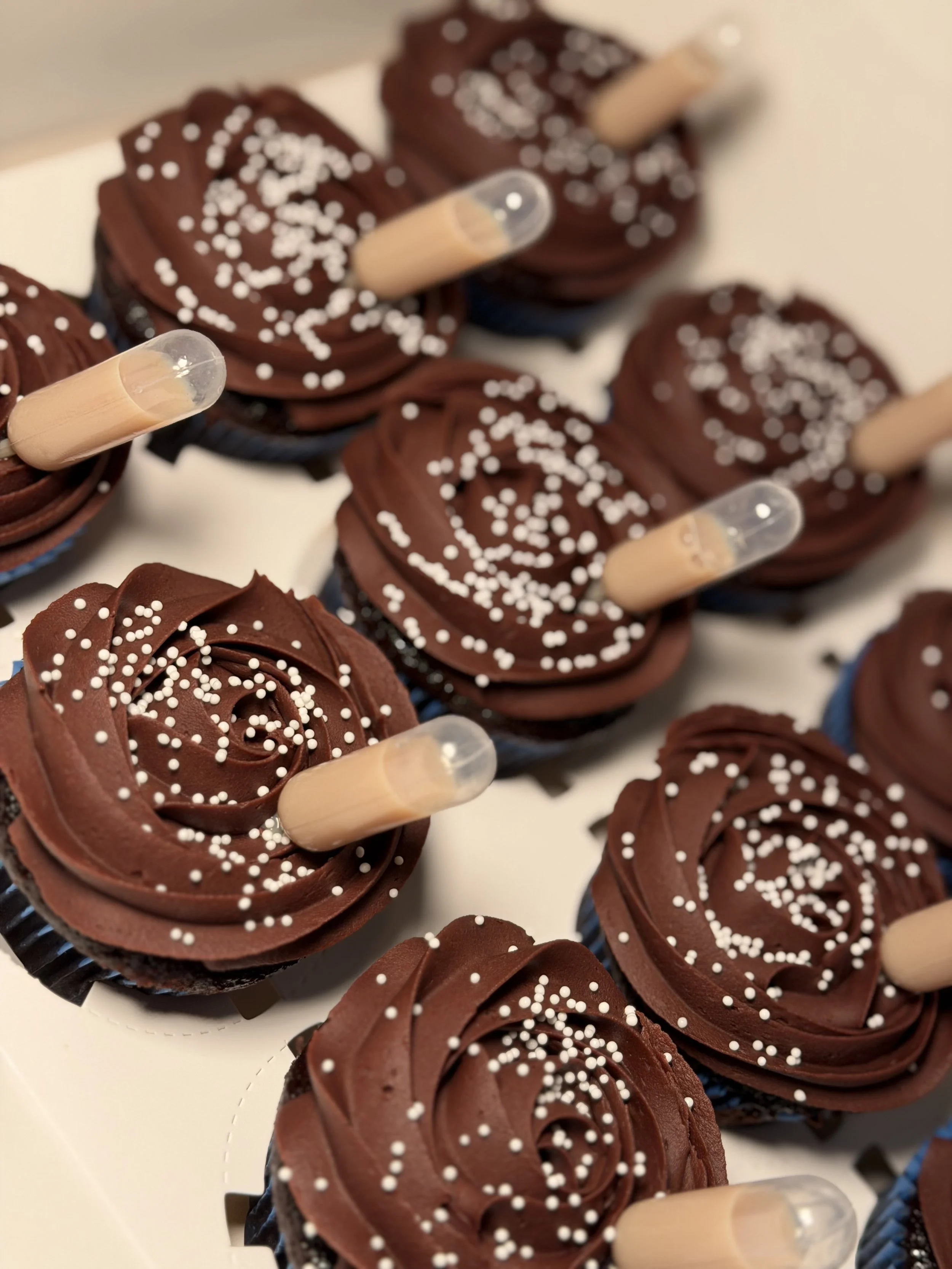 Chocolate cupcakes with chocolate buttercream and a pipette or cream liqueur