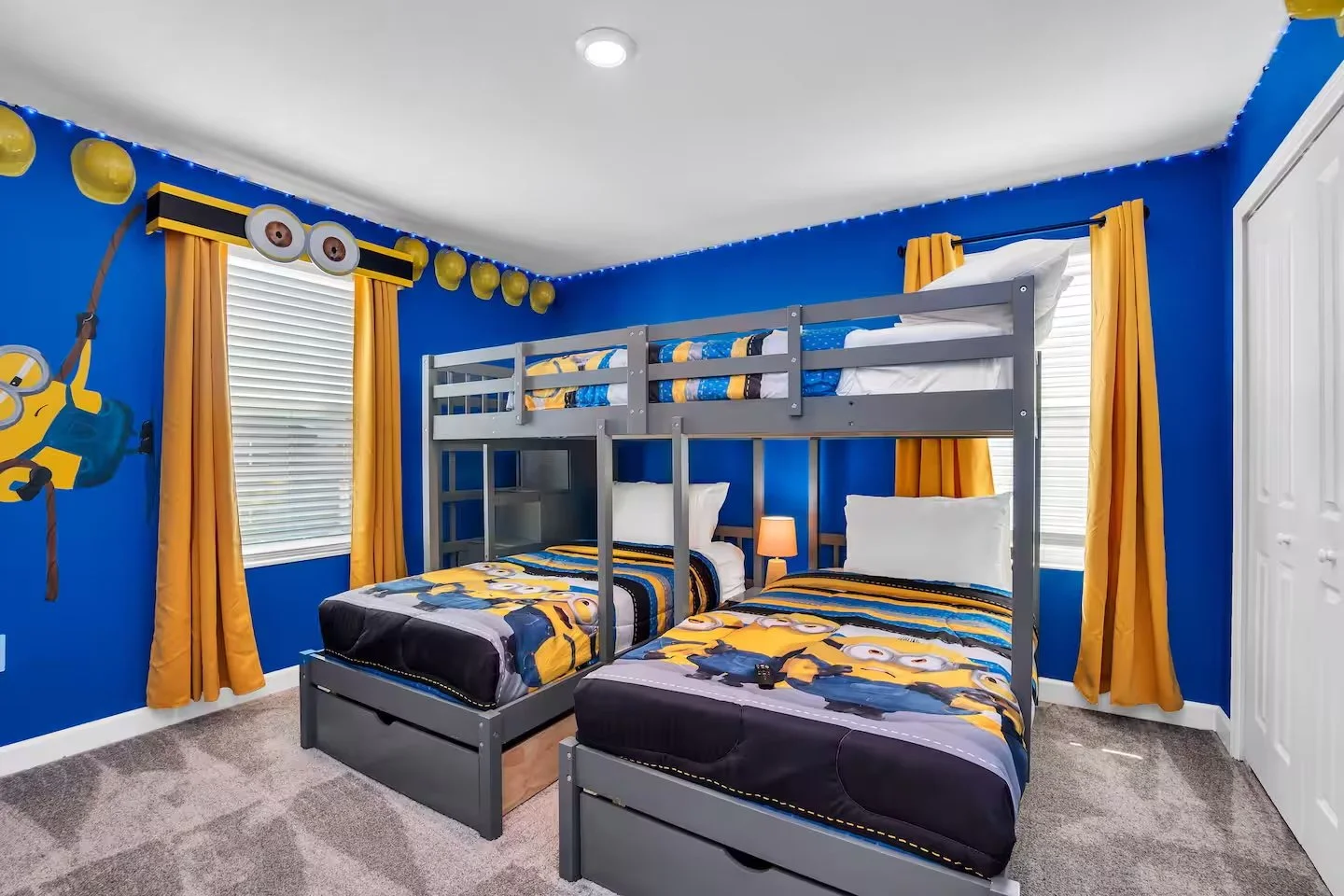 Children's bedroom decorated with Minions theme, including blue and yellow color scheme, Minions bedding, yellow curtains, and Minions characters on wall. Themed bedroom in Orlando, Florida. Vacation home for rent in storey lake with minion themes