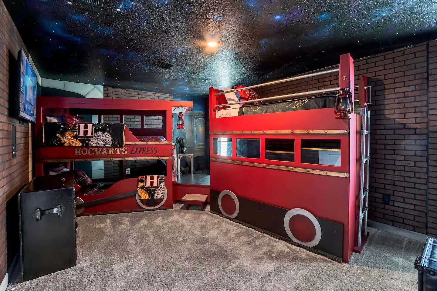 Harry Potter themed bedroom with bunk beds designed to resemble a red Hogwarts Express train, featuring windows, train wheels, and lanterns. Beautiful themed harry potter bedroom in vacation rental in kissimmee florida, in orlando. perfect for kids.
