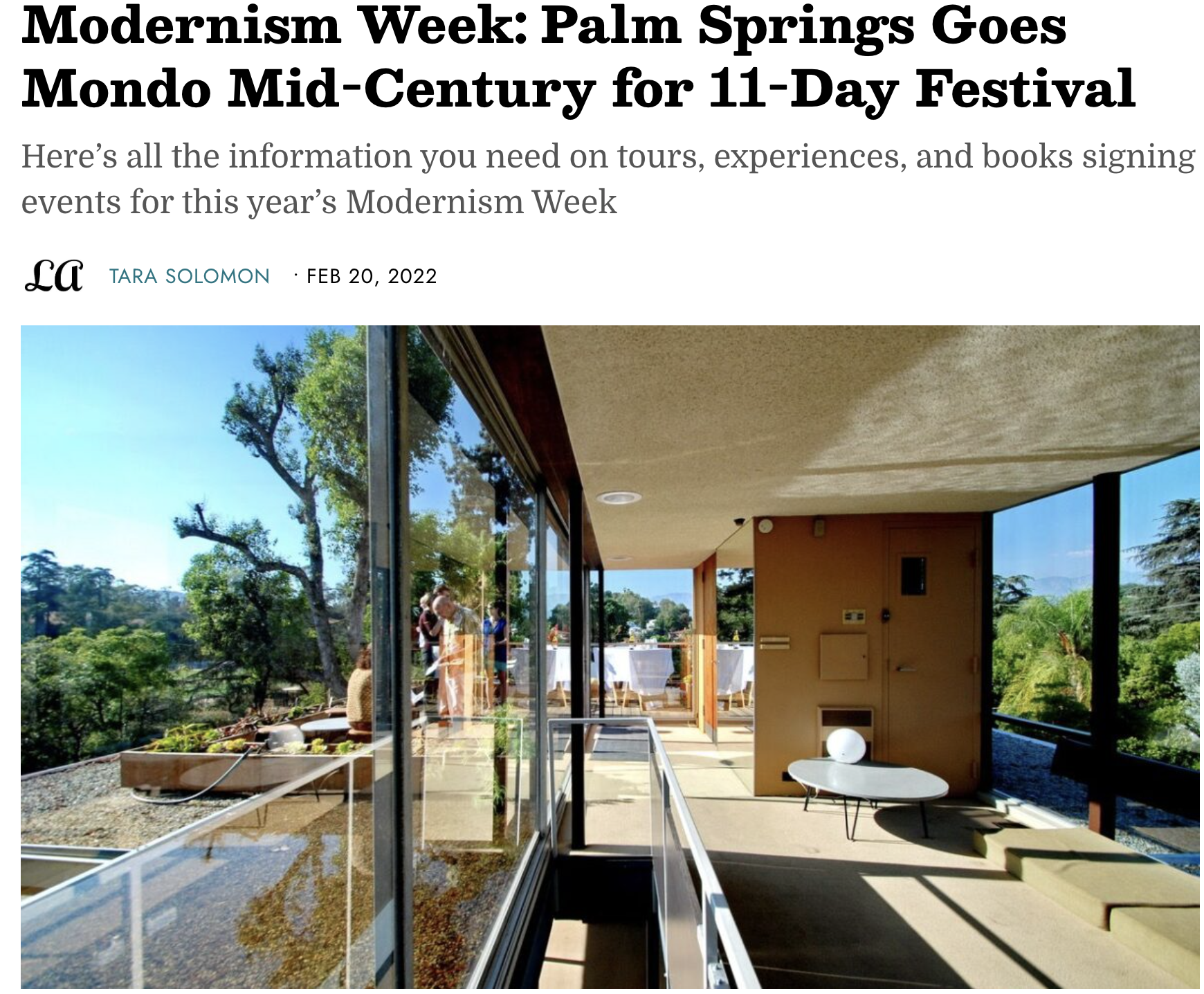 A bright indoor space with large glass windows overlooking a lush outdoor garden and trees, with outdoor tables set for an event.