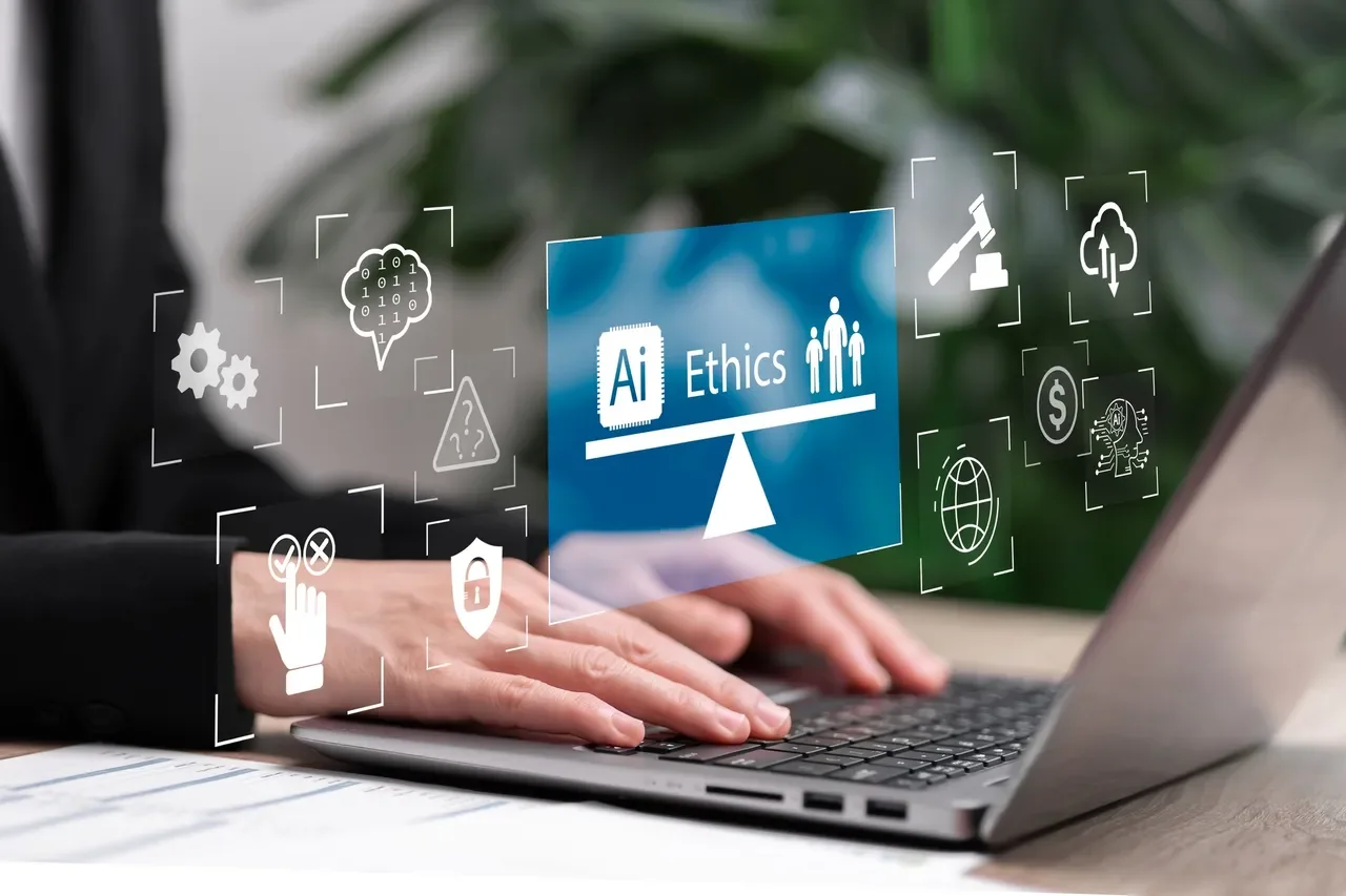Person typing on a laptop with holographic icons and a blue graphic labeled 'AI Ethics' and a seesaw graphic.