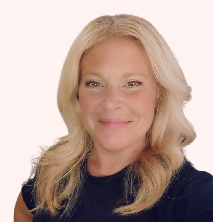 A woman with long blonde hair, smiling, wearing a black top, against a plain white background.