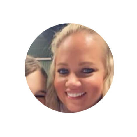 Close-up of a smiling blonde woman with blue eyes, partially visible face of another person, in a circular frame.