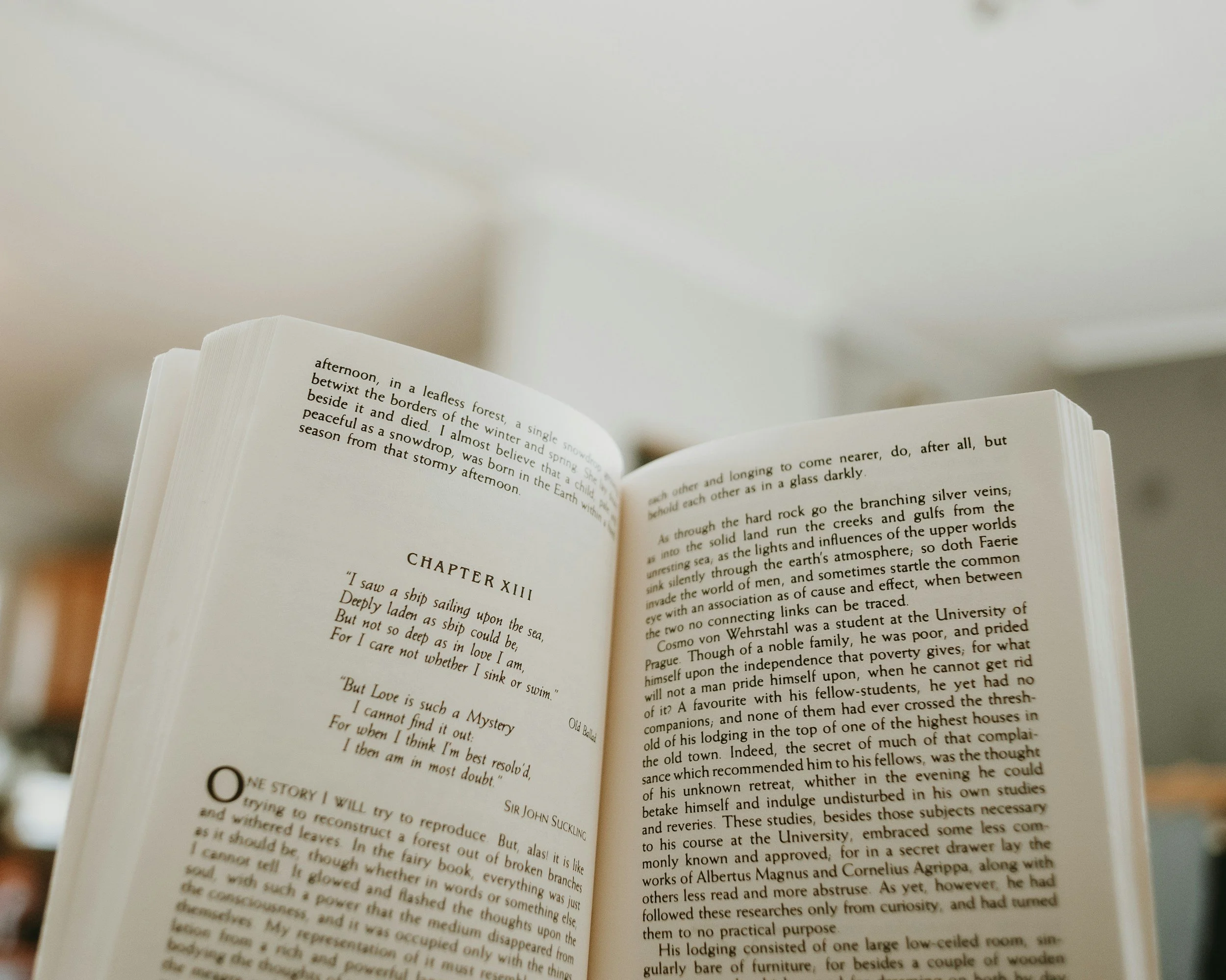 Person reading a book while sitting on the floor.