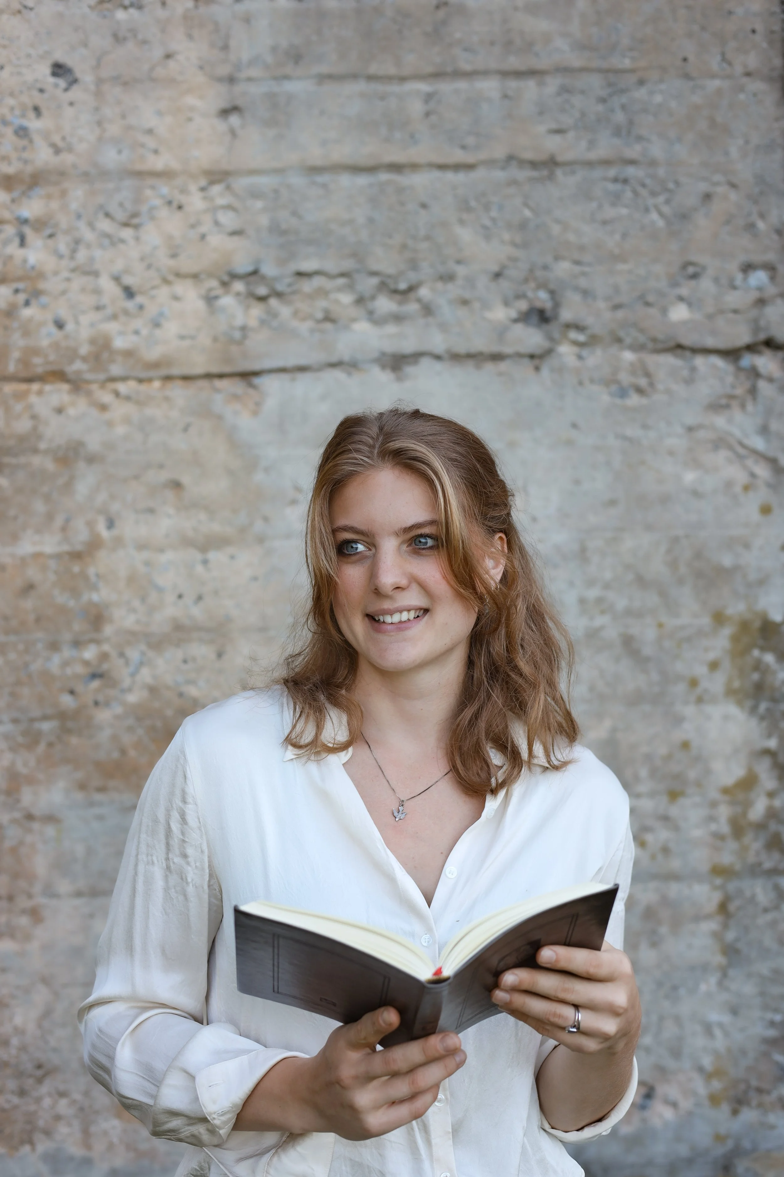 Maria holding a book and smiling