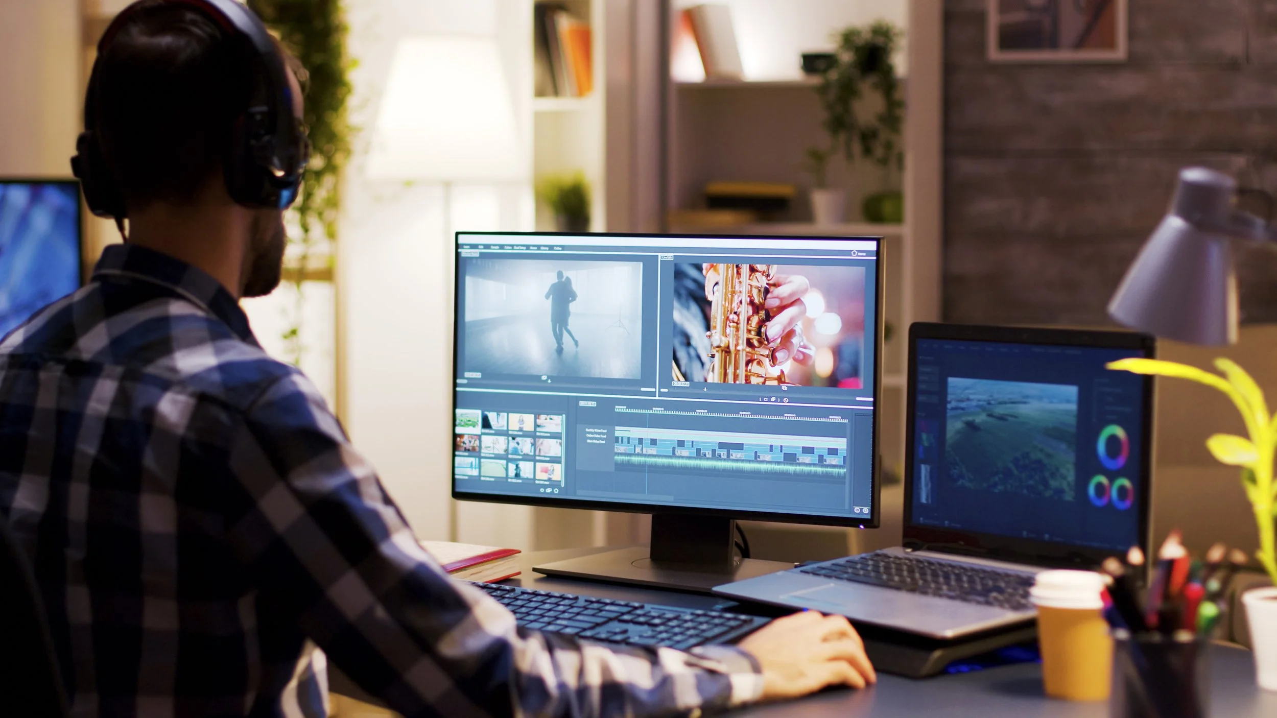 Man editing video on computer with dual monitors in a home office.