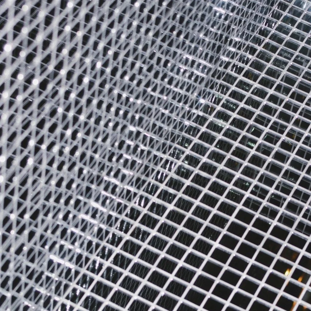 Close-up of a metal wire mesh or grid with a pattern of small square openings.