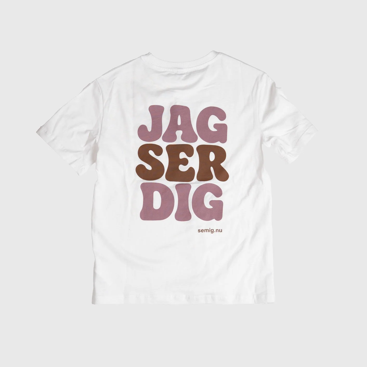 Vit oversize t-shirt i tjejmodell bakifrån med tryck ”Jag ser dig” i rosa och brunt