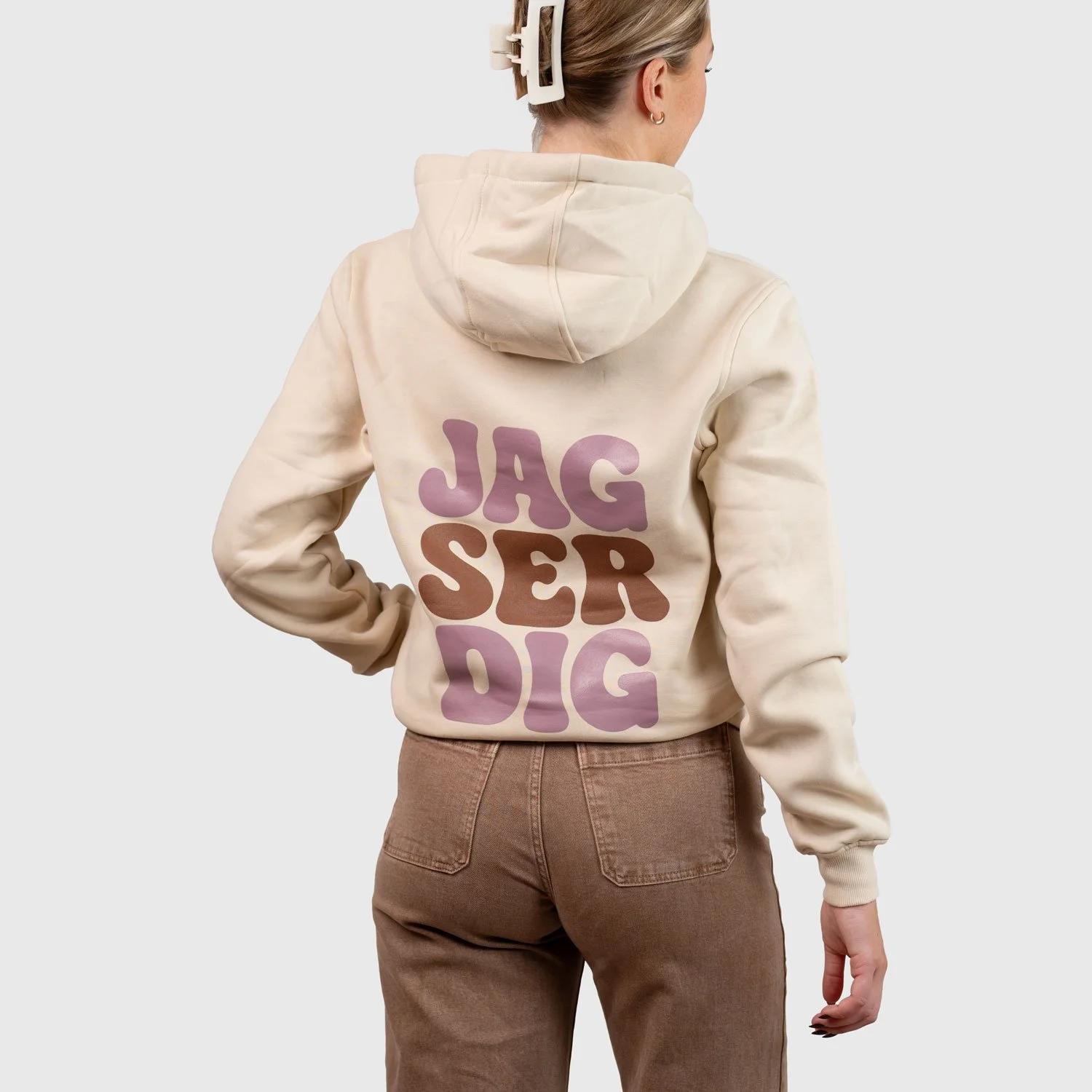 Kvinna i sandfärgad hoodie bakifrån med tryck ”Jag ser dig”