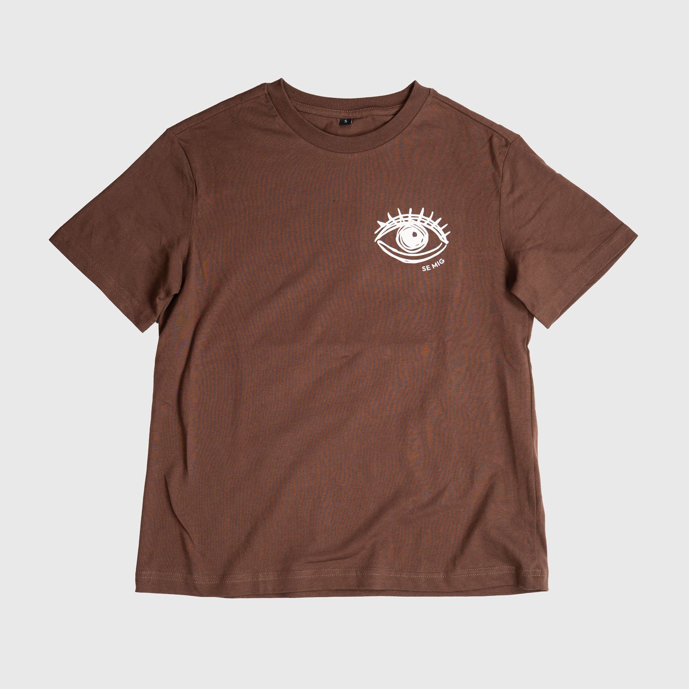 Brun oversize t-shirt i tjejmodell framifrån med liten ögonlogga
