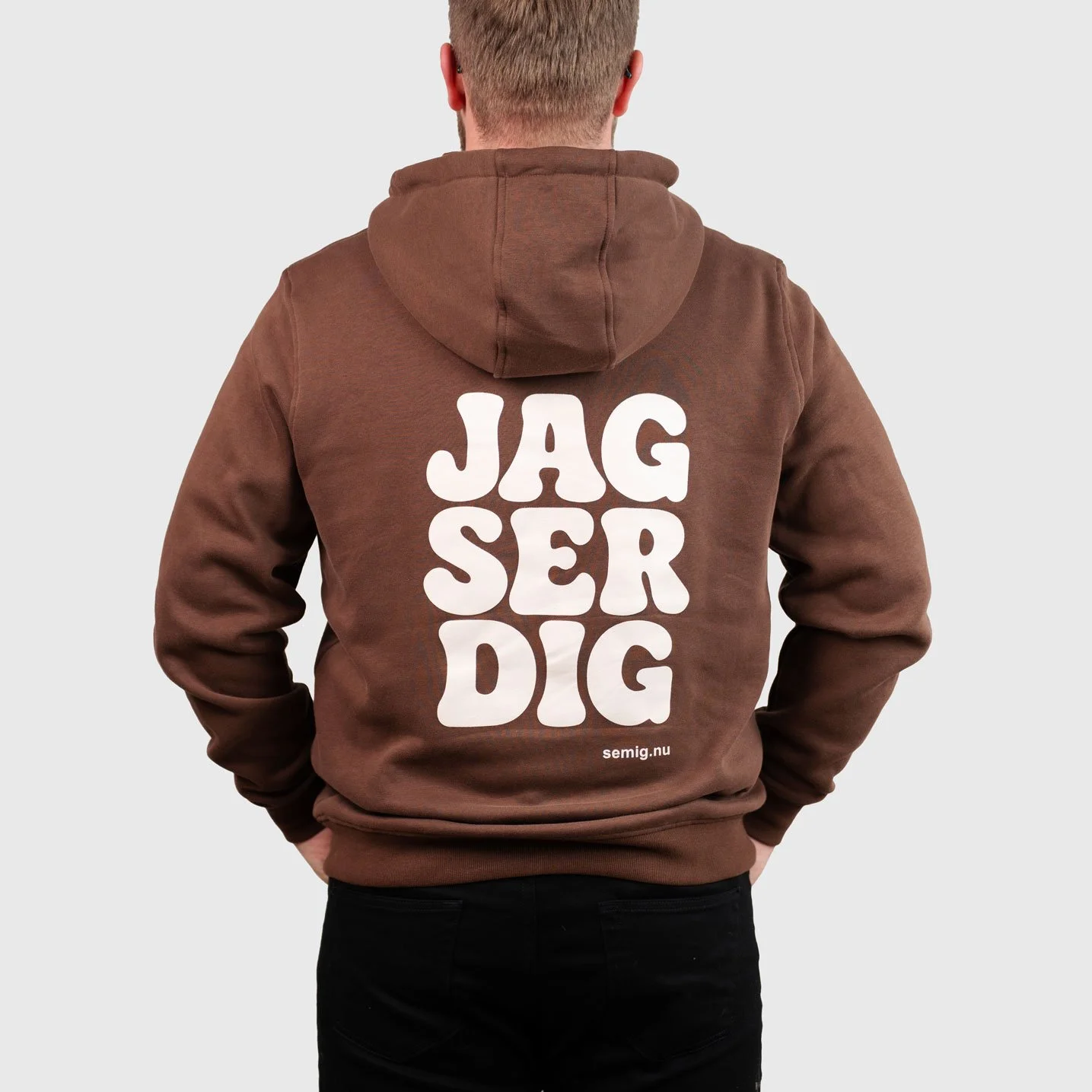Man i brun hoodie bakifrån med trycket ”Jag ser dig”