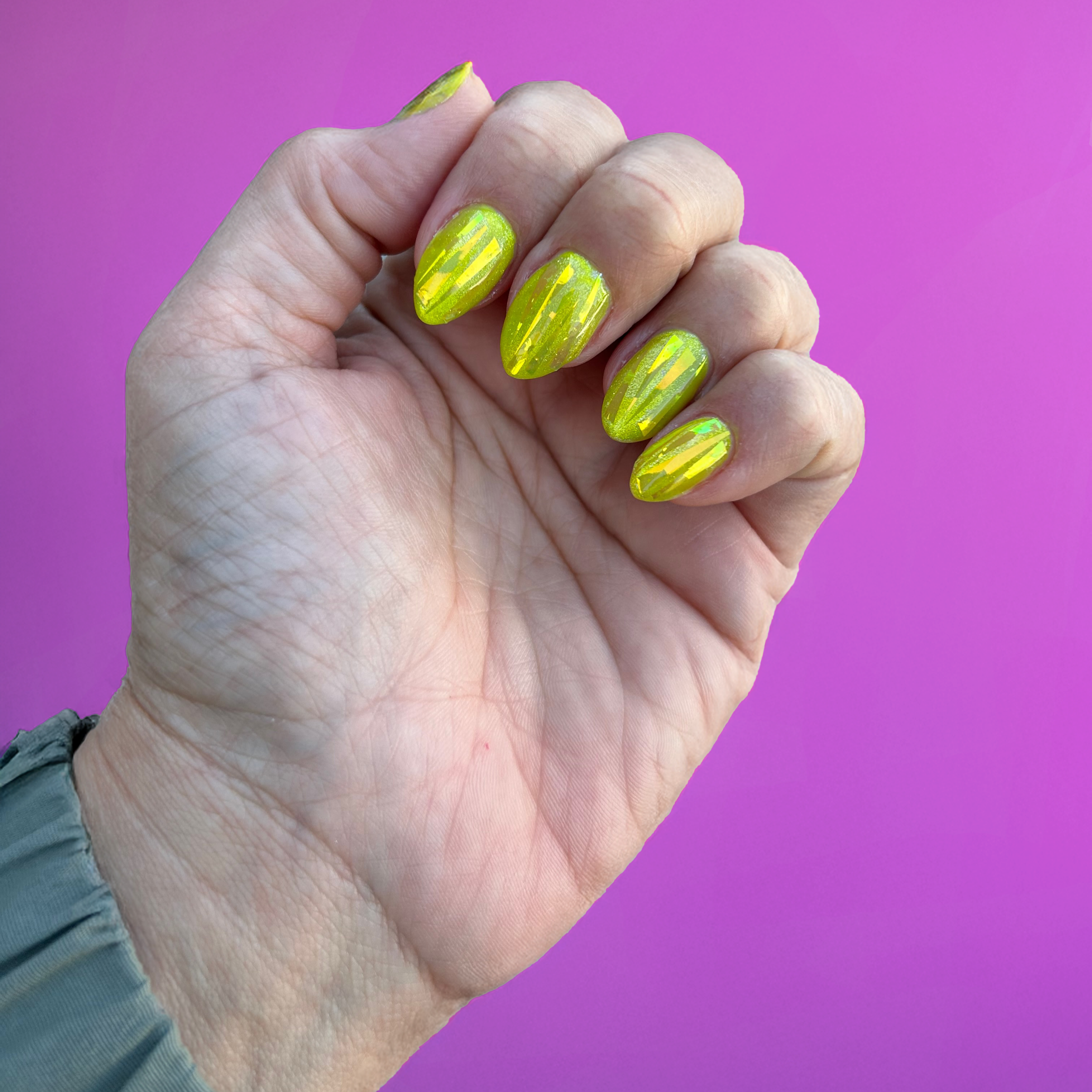 Bright yellow glitter manicured nails with encapsulated foil.