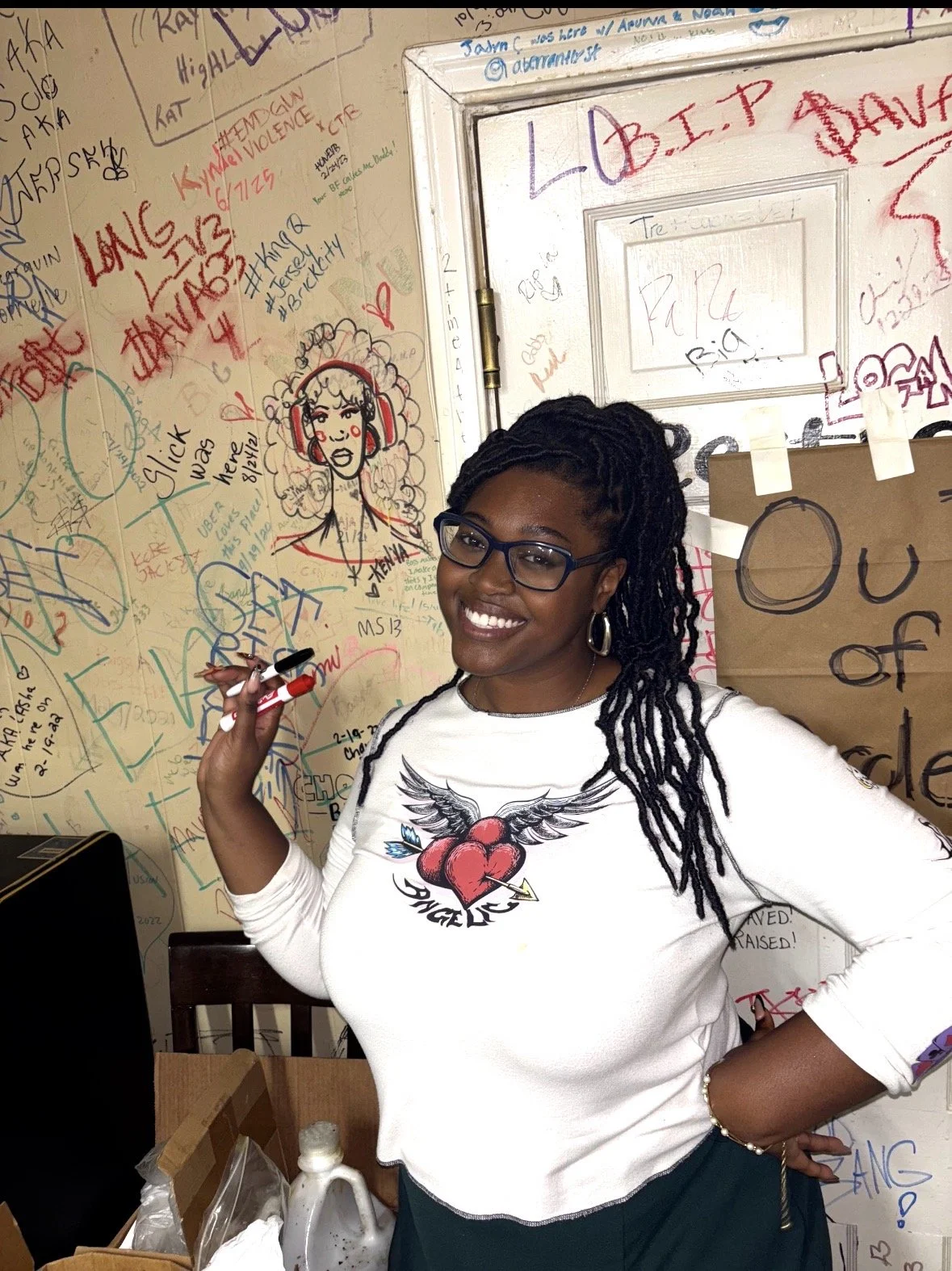 Artist Kenya Brown leaving her mark as she draws a woman with headphones drawn in marker at Denton's local soul food spot Clara's Kitchen which serves BBQ and soul food including catfish, ribs, and banana pudding. 