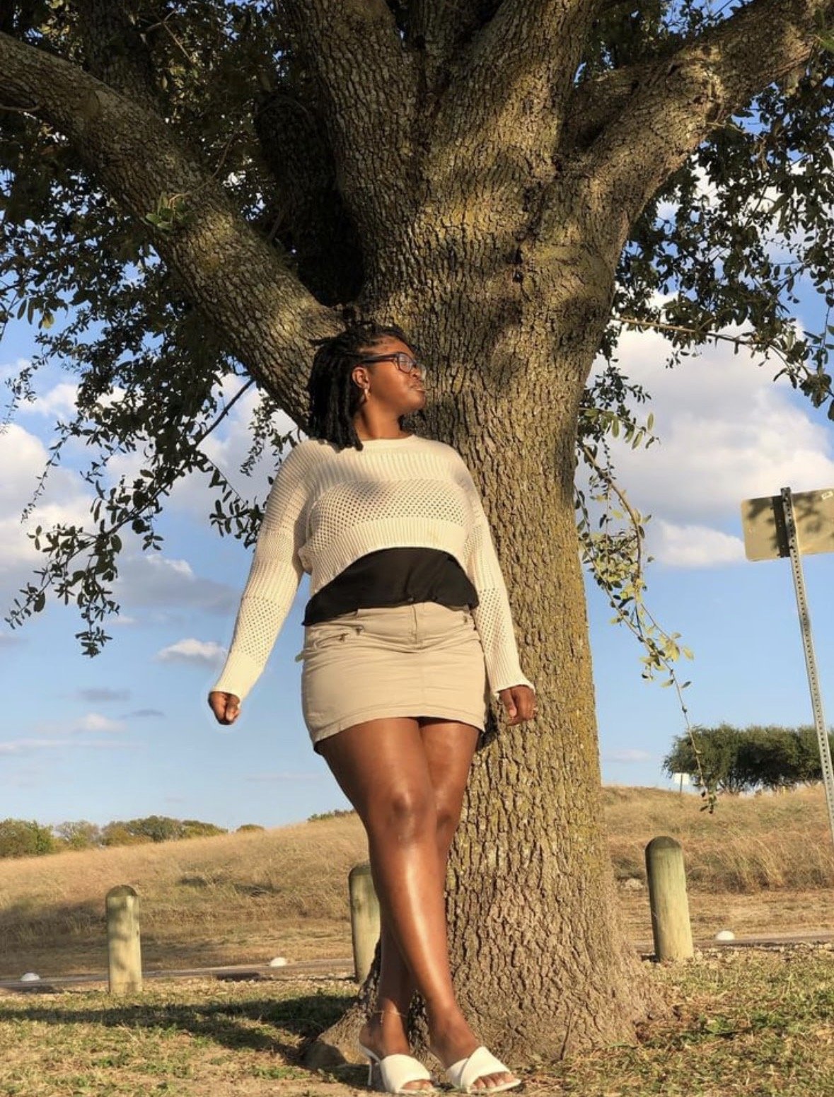 Kenya Brown posing for Instagram feed at x.purefeelings.x on Instagram. Dressed in thrifted apparel, mule heels and shoulder length faux locks.