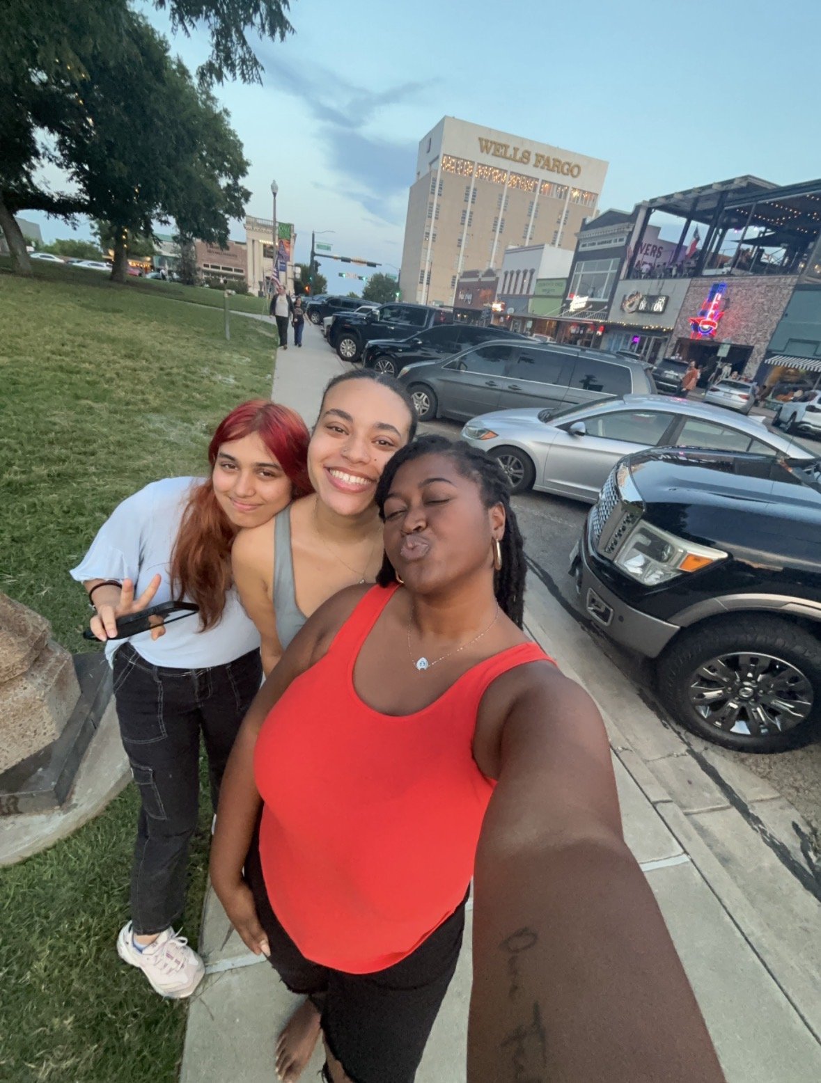 Artist Kenya Brown taking a photo with Denton, Tx local artists after they stop by to purchase some art pieces on Denton Square.
