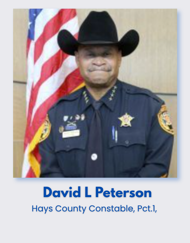 Hays County Constable David L. Peterson in uniform standing in front of an American flag.
