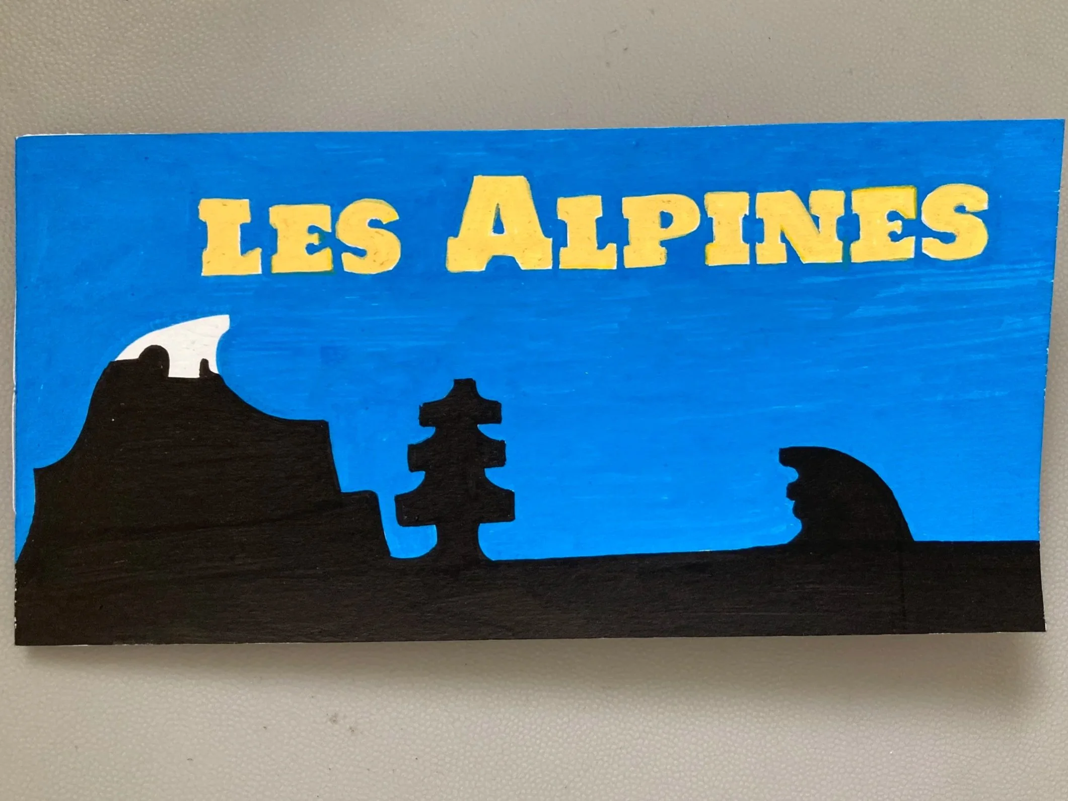 Une illustration représentant des montagnes des Alpes avec le texte 'Les Alpes' en jaune.