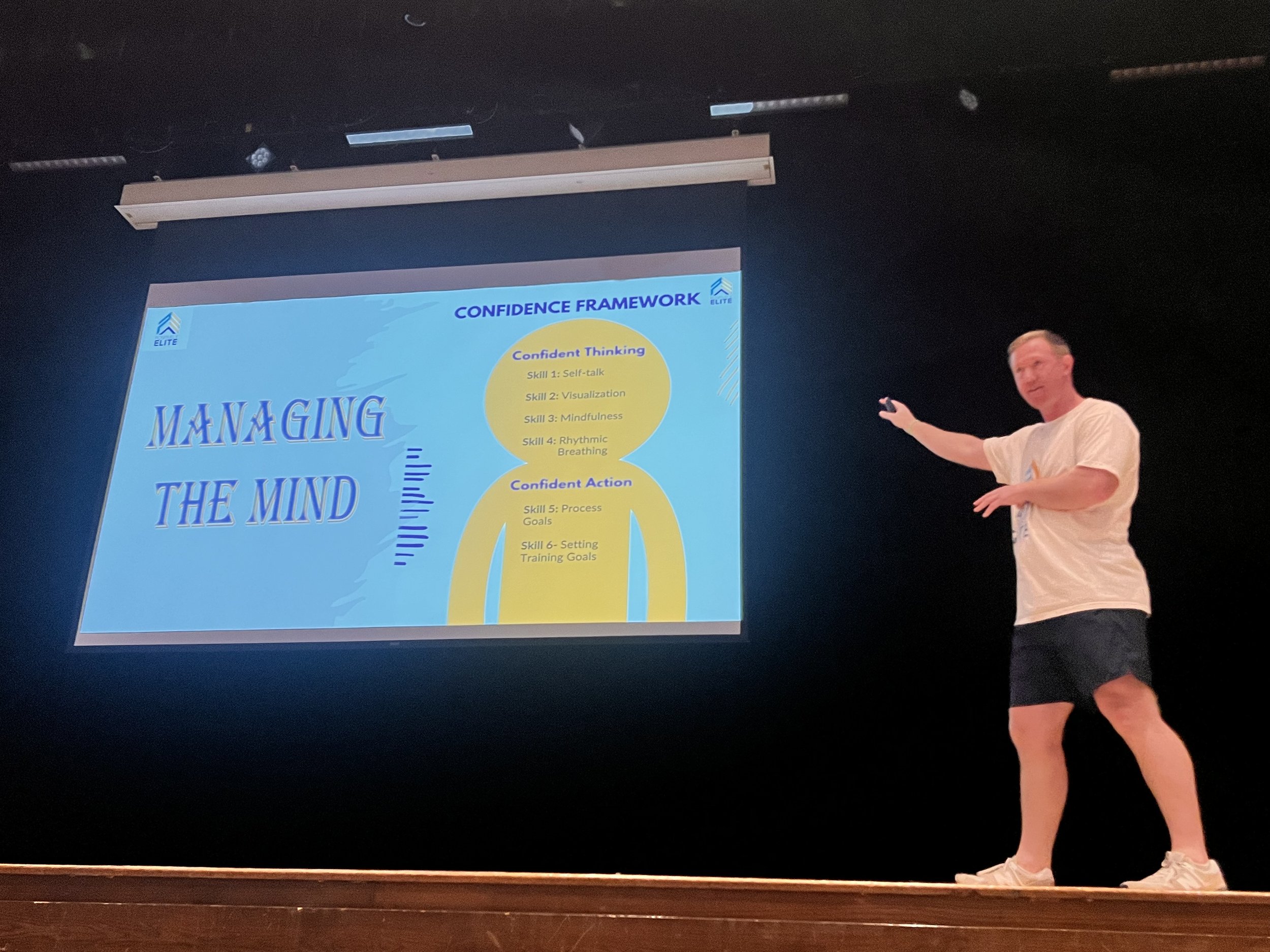 Several people seated at a long wooden table during a meeting, with notebooks and pens in front of them.