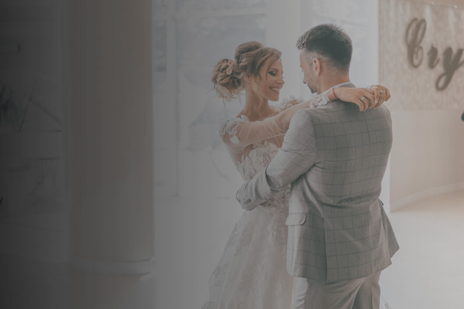 A bride and groom dancing indoors during their wedding celebration.