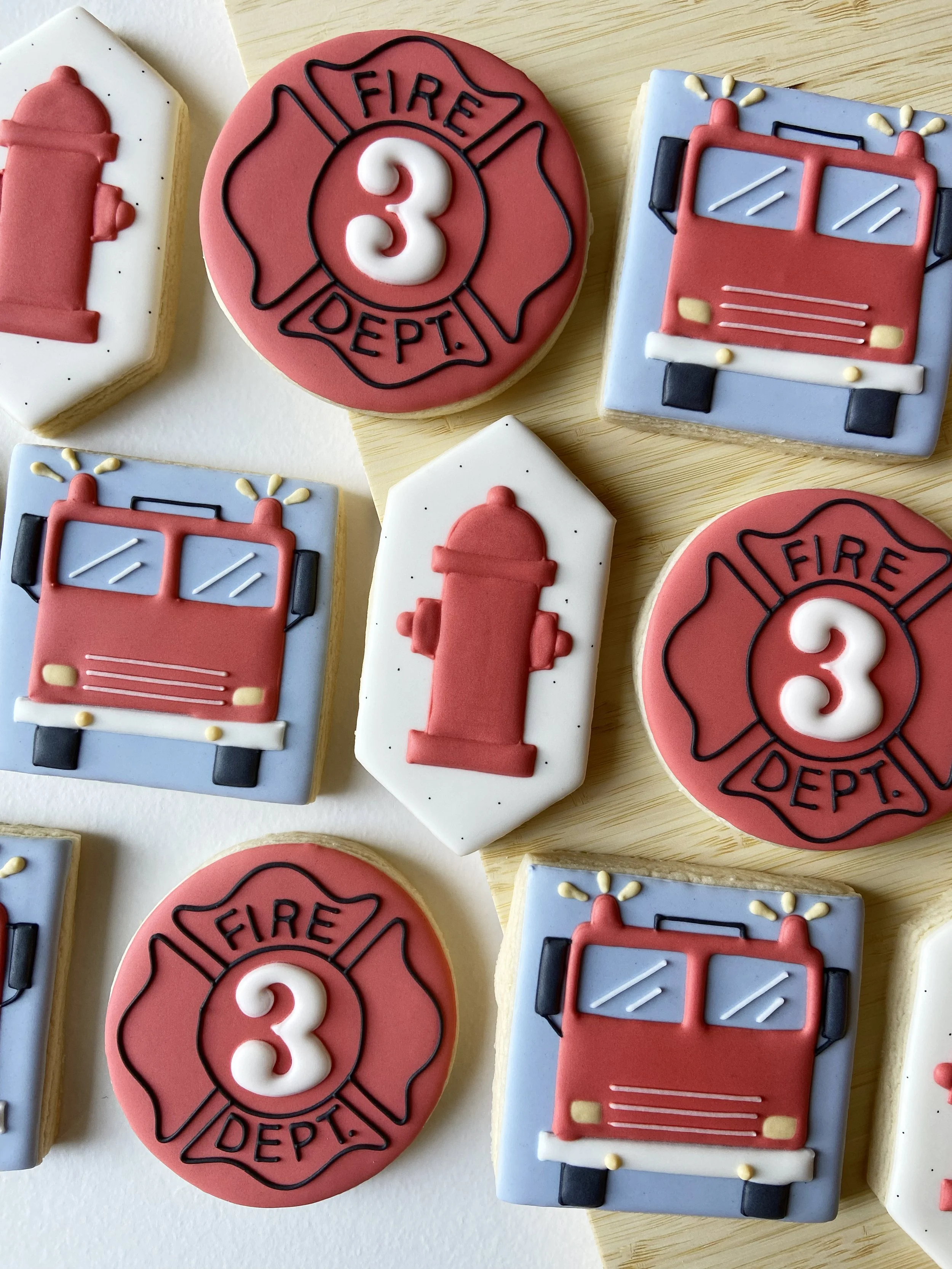 Decorated cookies with fire truck and fire department symbols, including fire hydrant and fire department emblem.