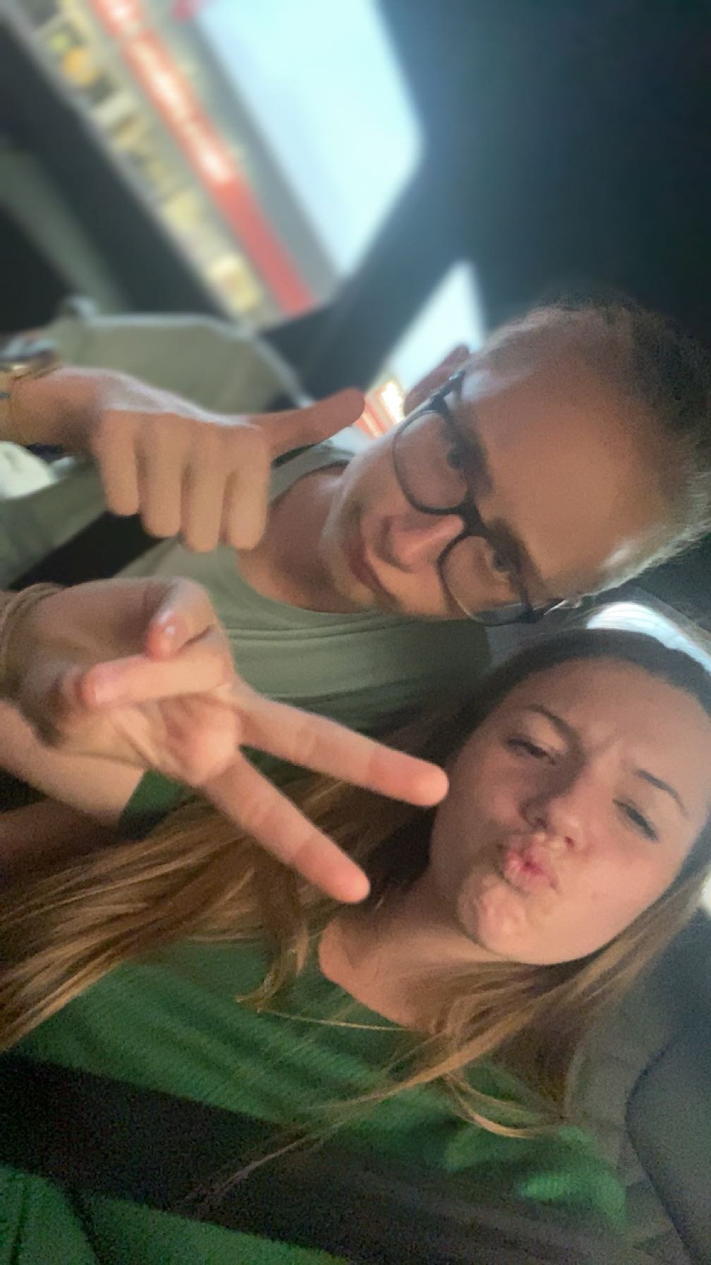 Ein Junge mit Brille macht einen Daumen hoch, ein Mädchen neben ihm macht ein Peace-Zeichen und pustet die Lippen.