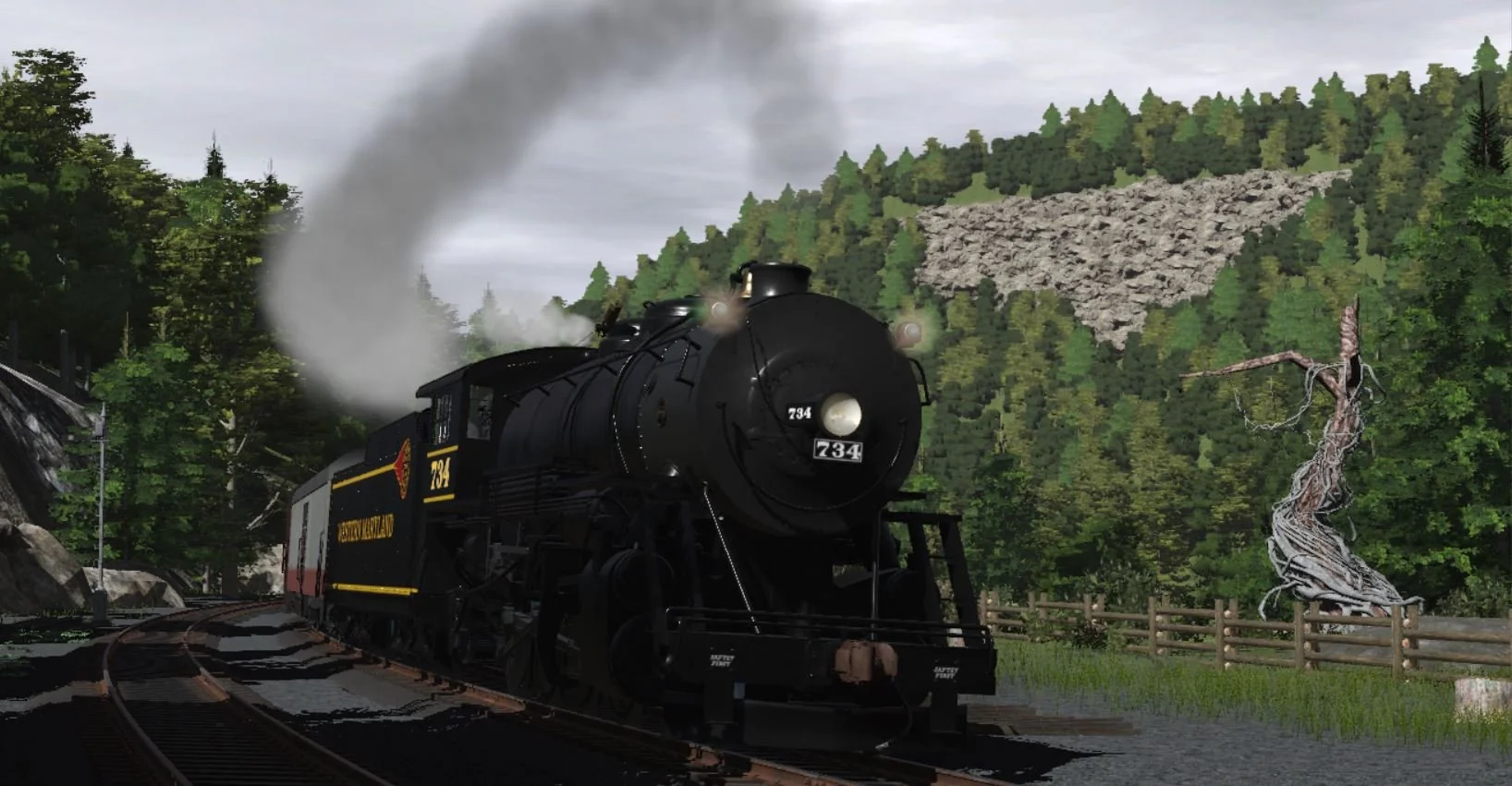A black steam train traveling on railway tracks through a forested mountainous landscape with smoke coming out of its chimney.